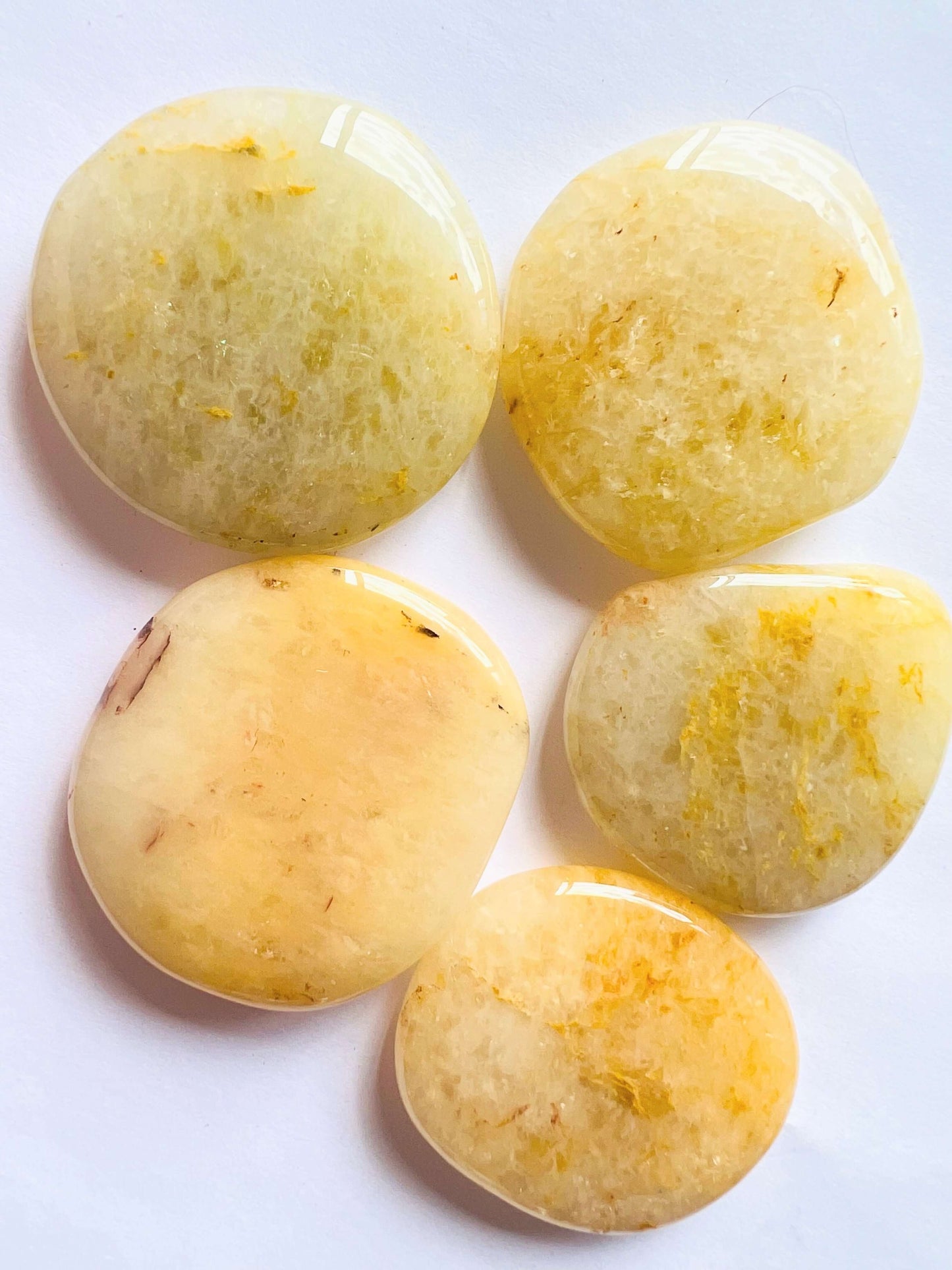 Golden healer palm stones on white surface. 