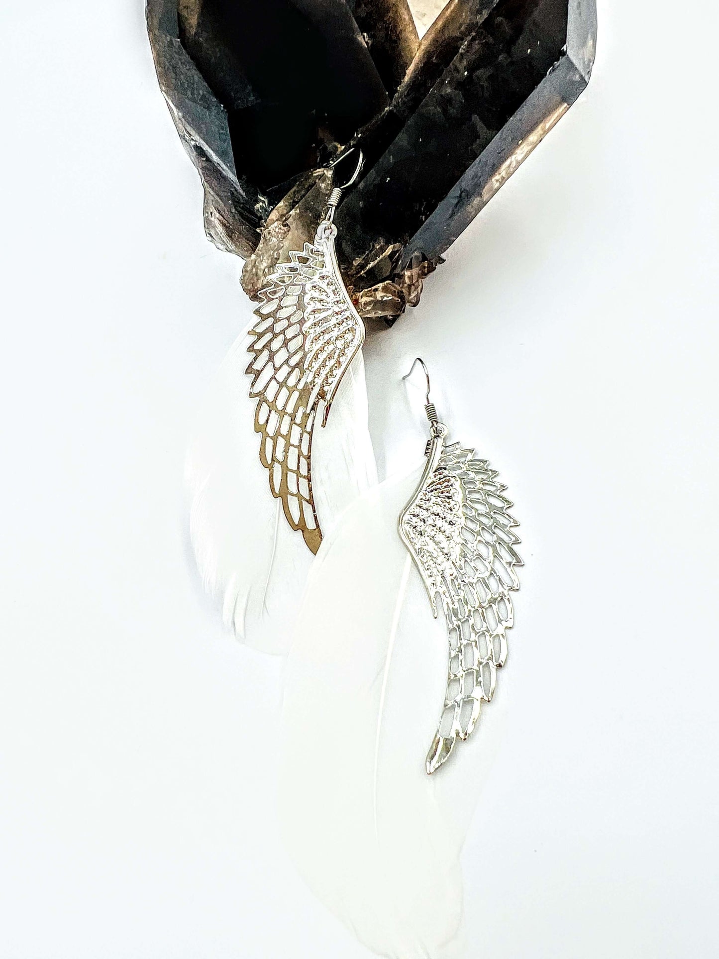 white feather angel wing earrings with metal feather overlay on white background