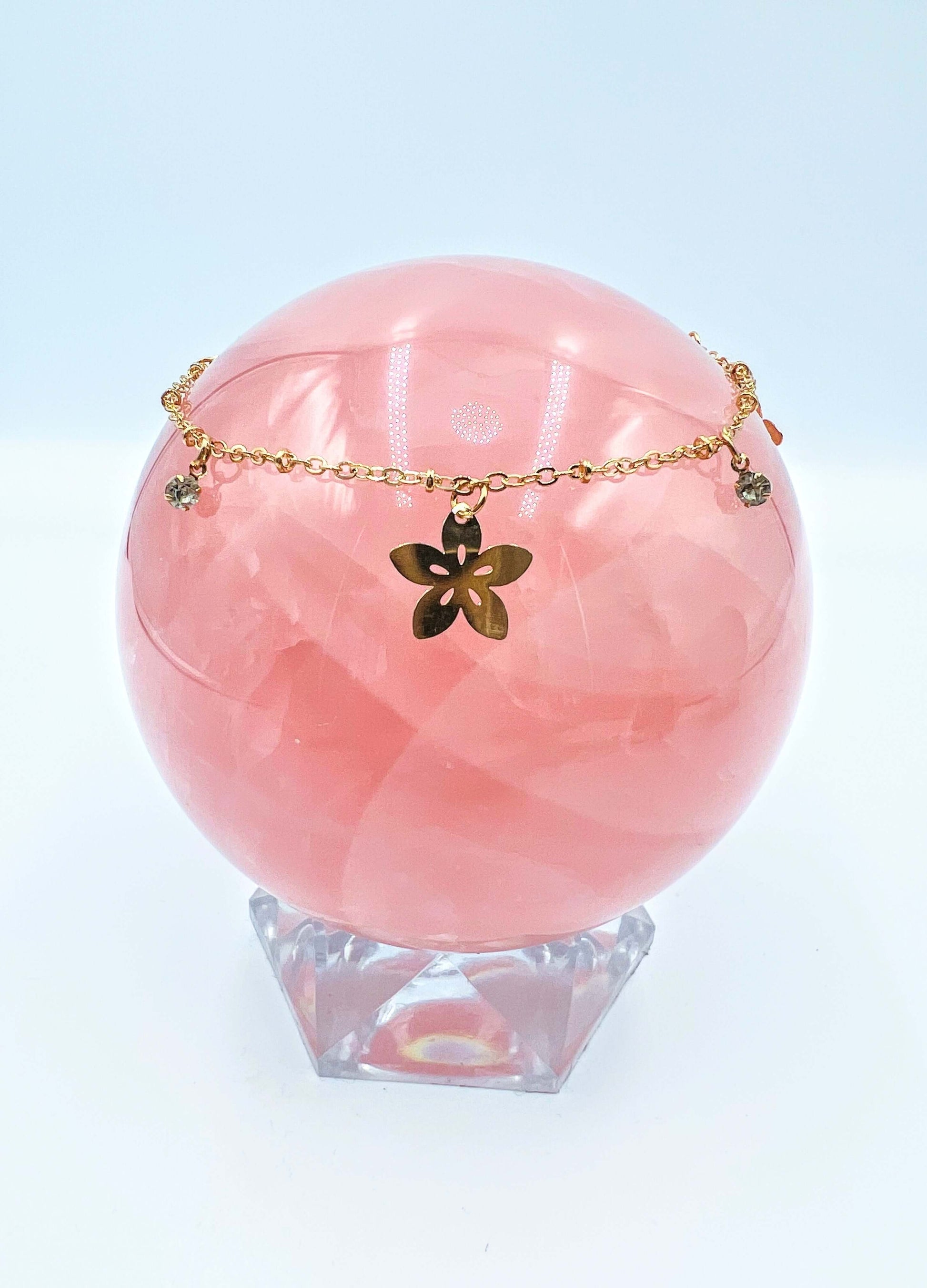 Ankle bracelets sitting on a large rose quartz sphere.