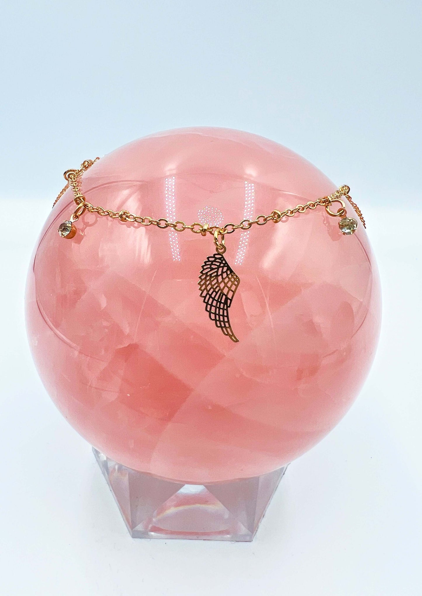 Ankle bracelets sitting on a large rose quartz sphere.