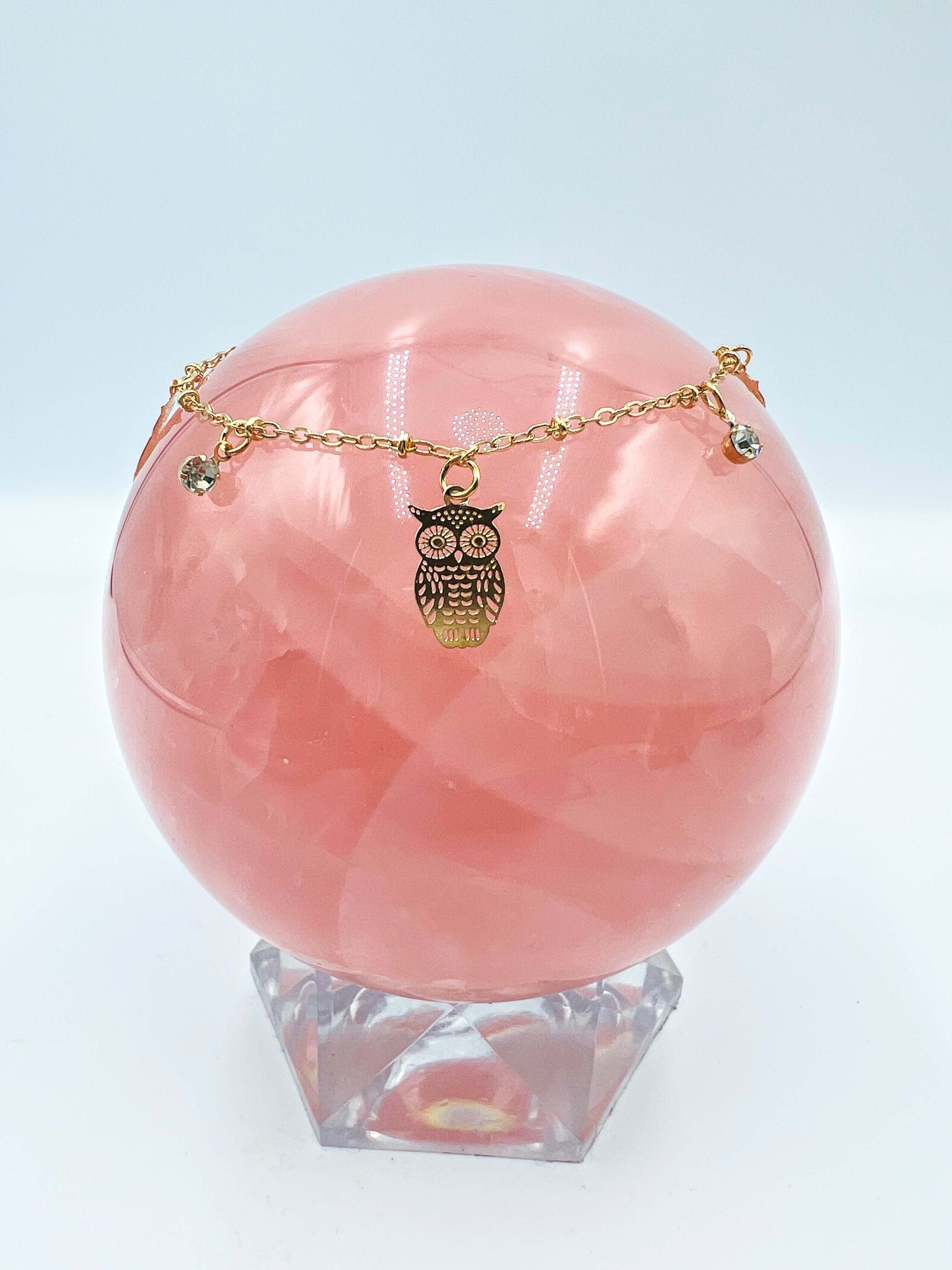 Ankle bracelets sitting on a large rose quartz sphere.