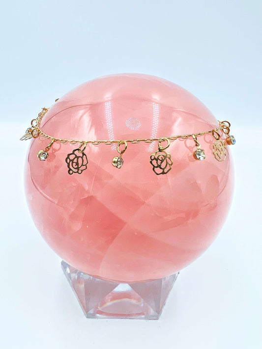 Ankle bracelets sitting on a large rose quartz sphere. 