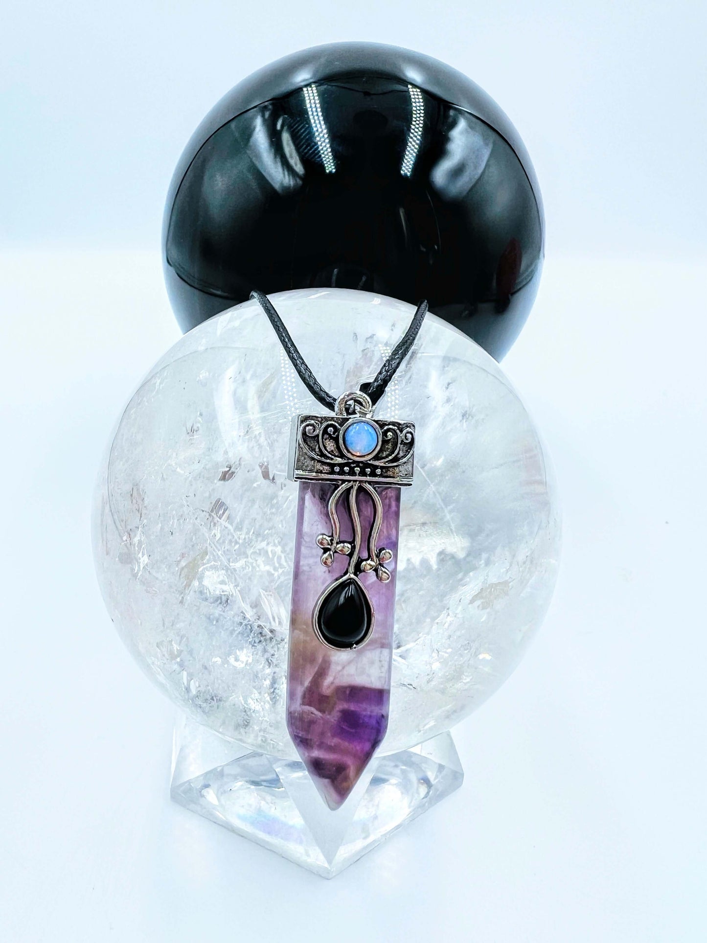 Amethyst Crystal pendant sitting on clear quartz sphere. 