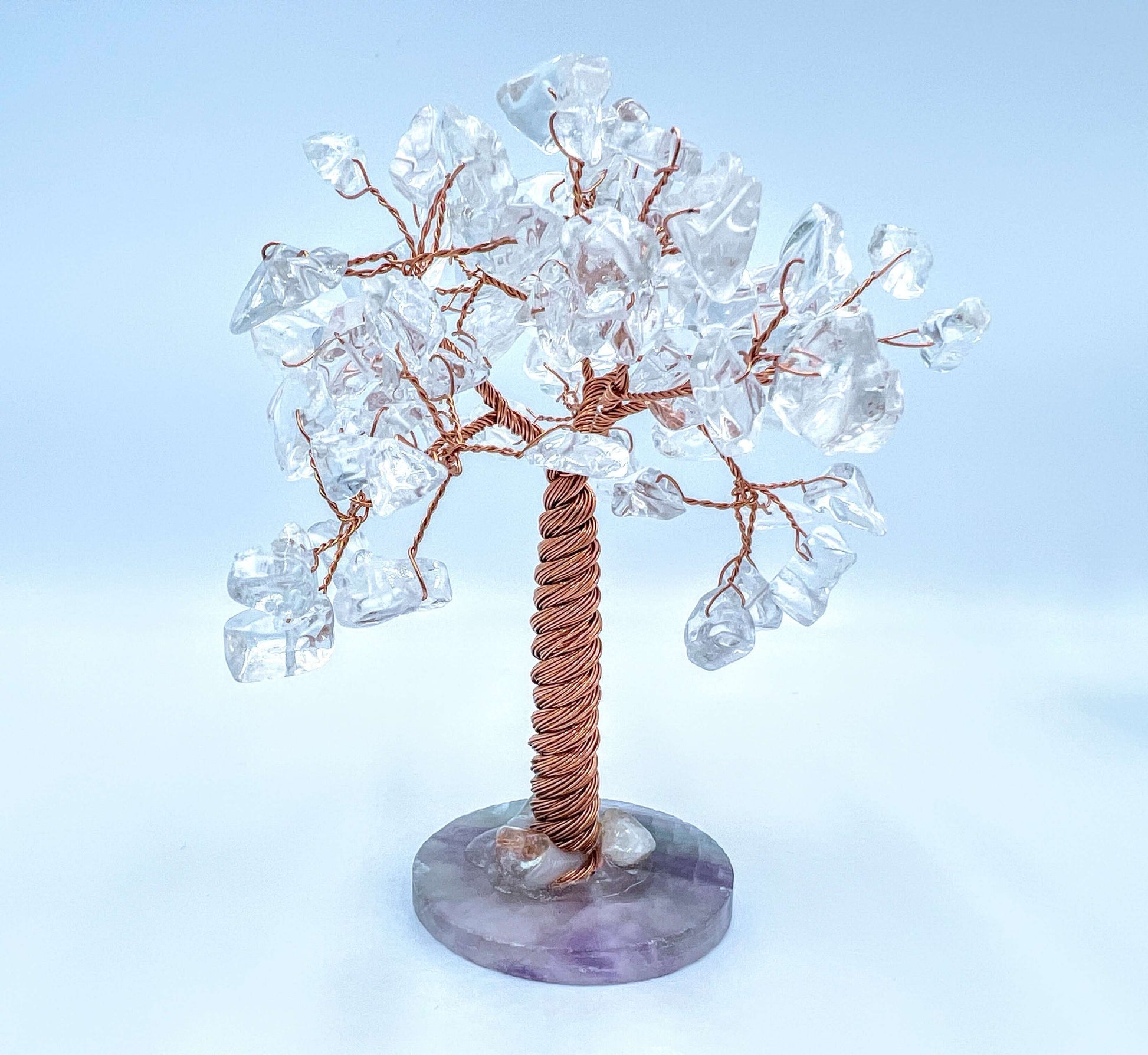 Clear quartz crystal gem tree on white surface