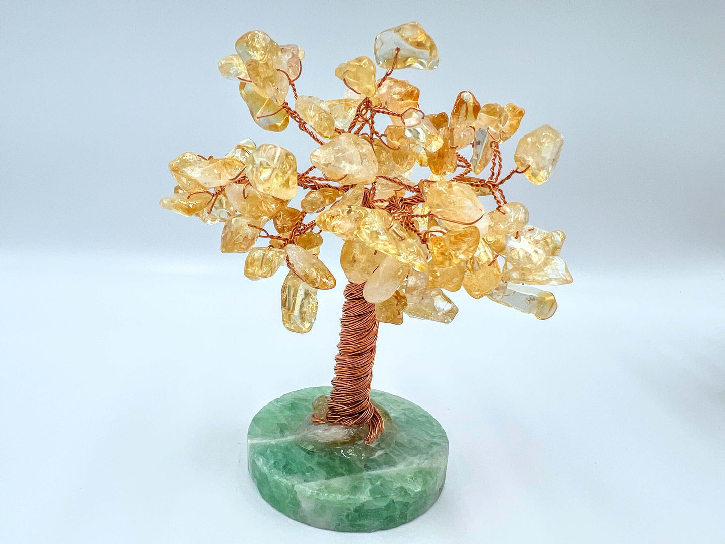 Citrine crystal gem tree on white surface 