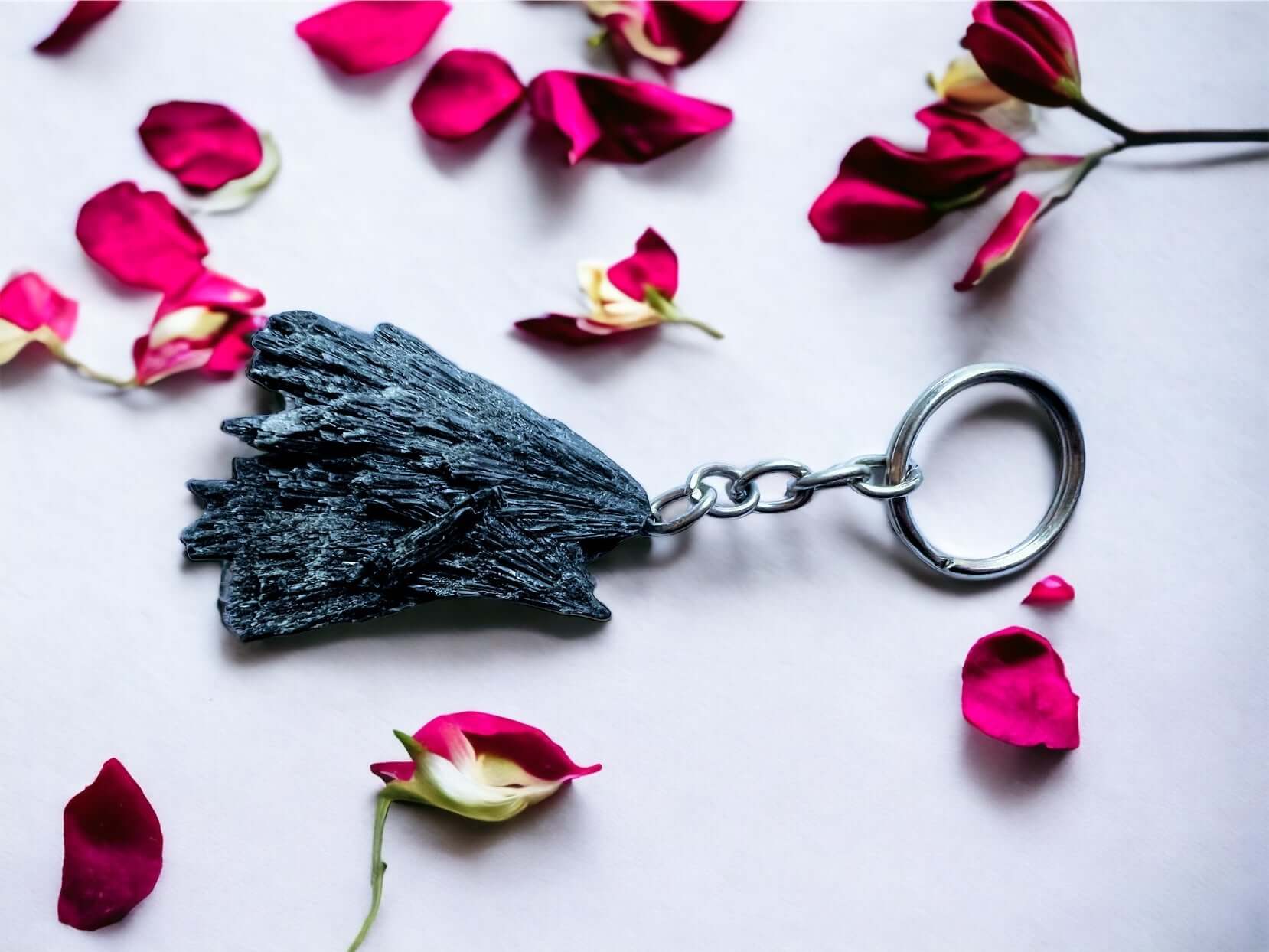 Crystal key rings on white surface with petals