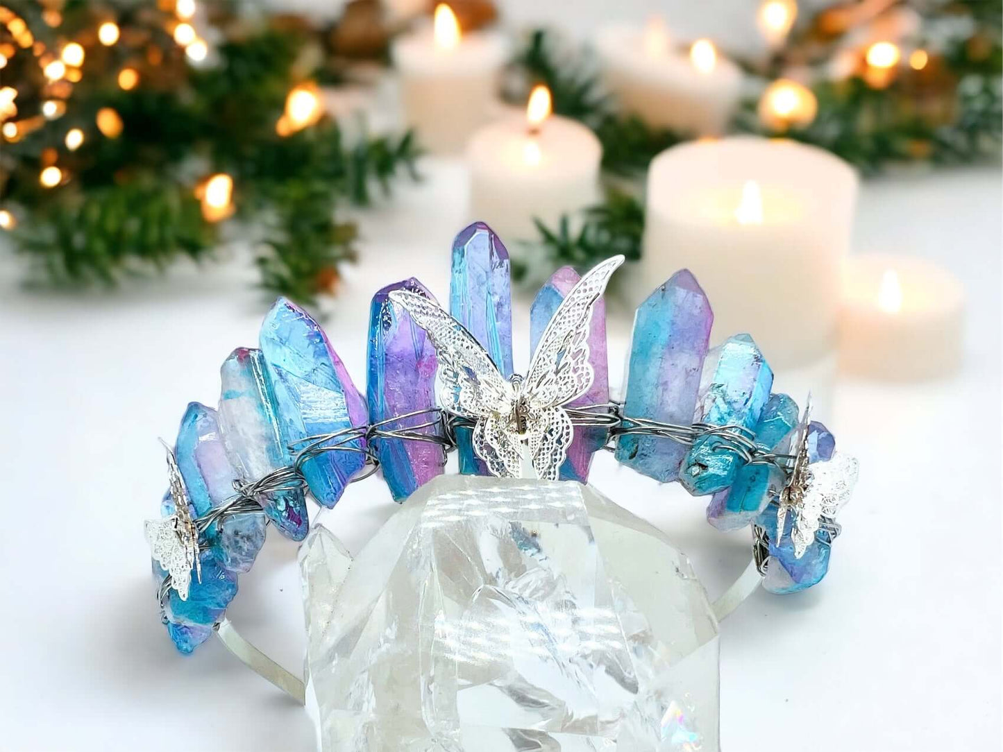 Crystal crown tiara on white surface with candles in background.