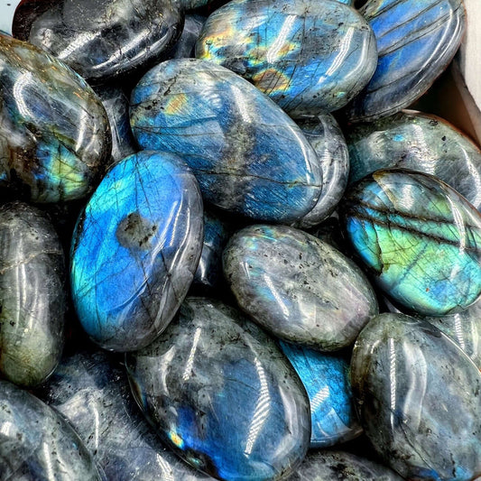 Polished labradorite stone displaying iridescent colors and intricate patterns.