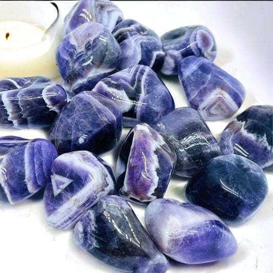 Several chevron amethyst tumbled stones. 