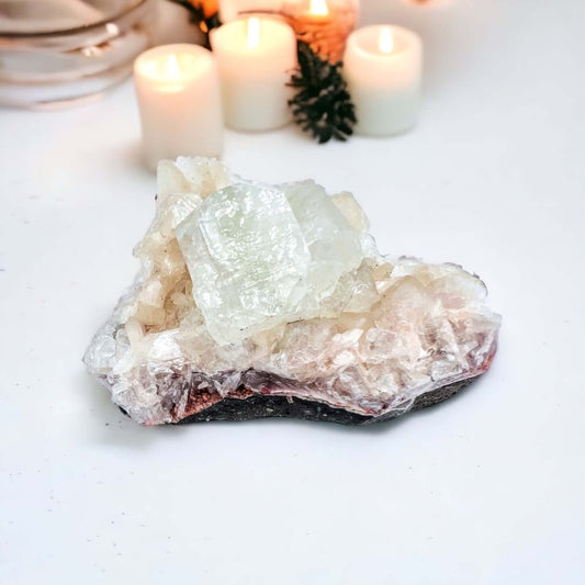 Apophyllite cluster with a candle in background