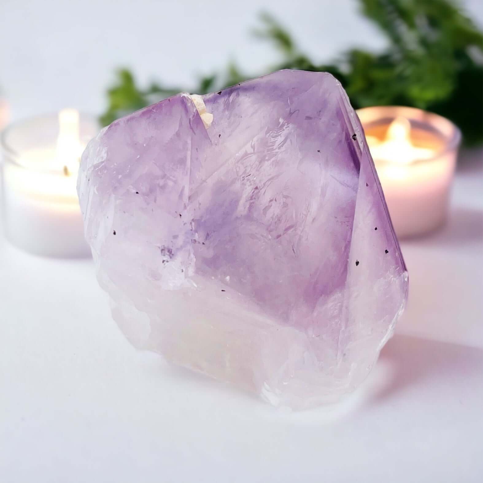 Amethyst point with small candle in background