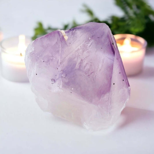 Amethyst point with small candle in background