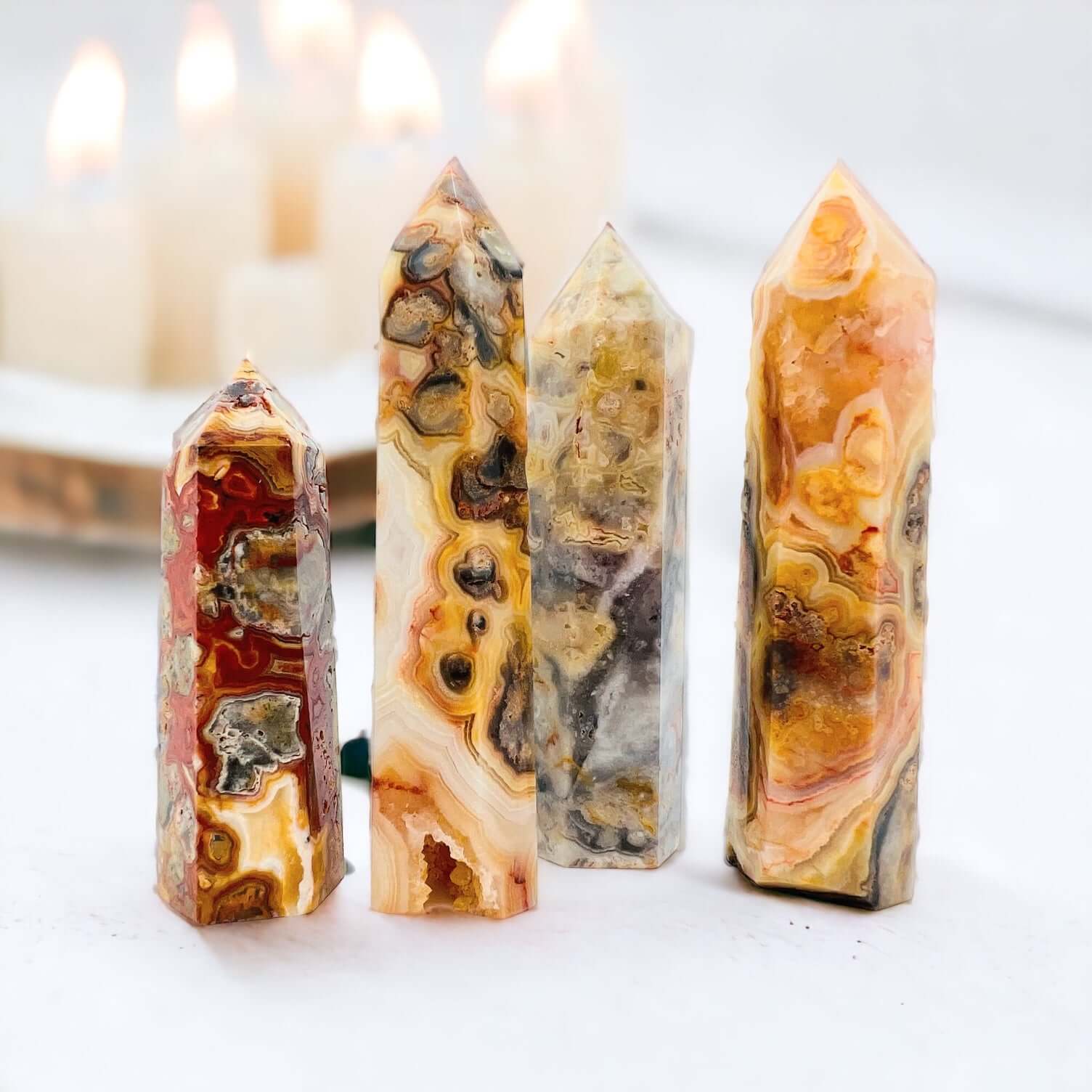 Crazy lace agate points on white background with candles. 