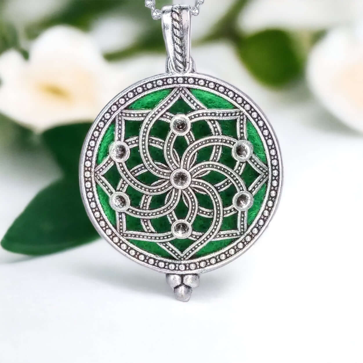 Flower pattern Diffuser locket on white surface with scattered petals.