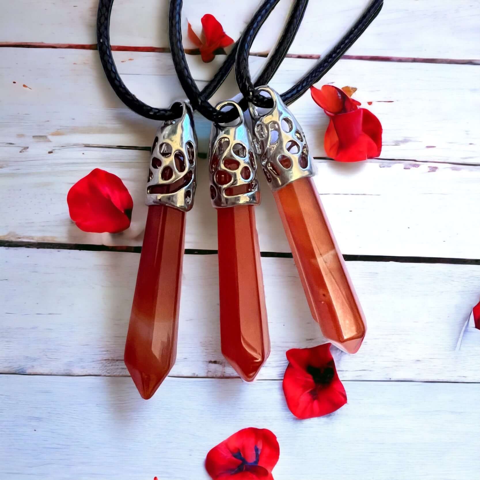 Carnelian Long crystal pendant on white background with petals.