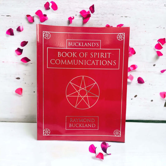 Red book of spirit communications on white surface. 