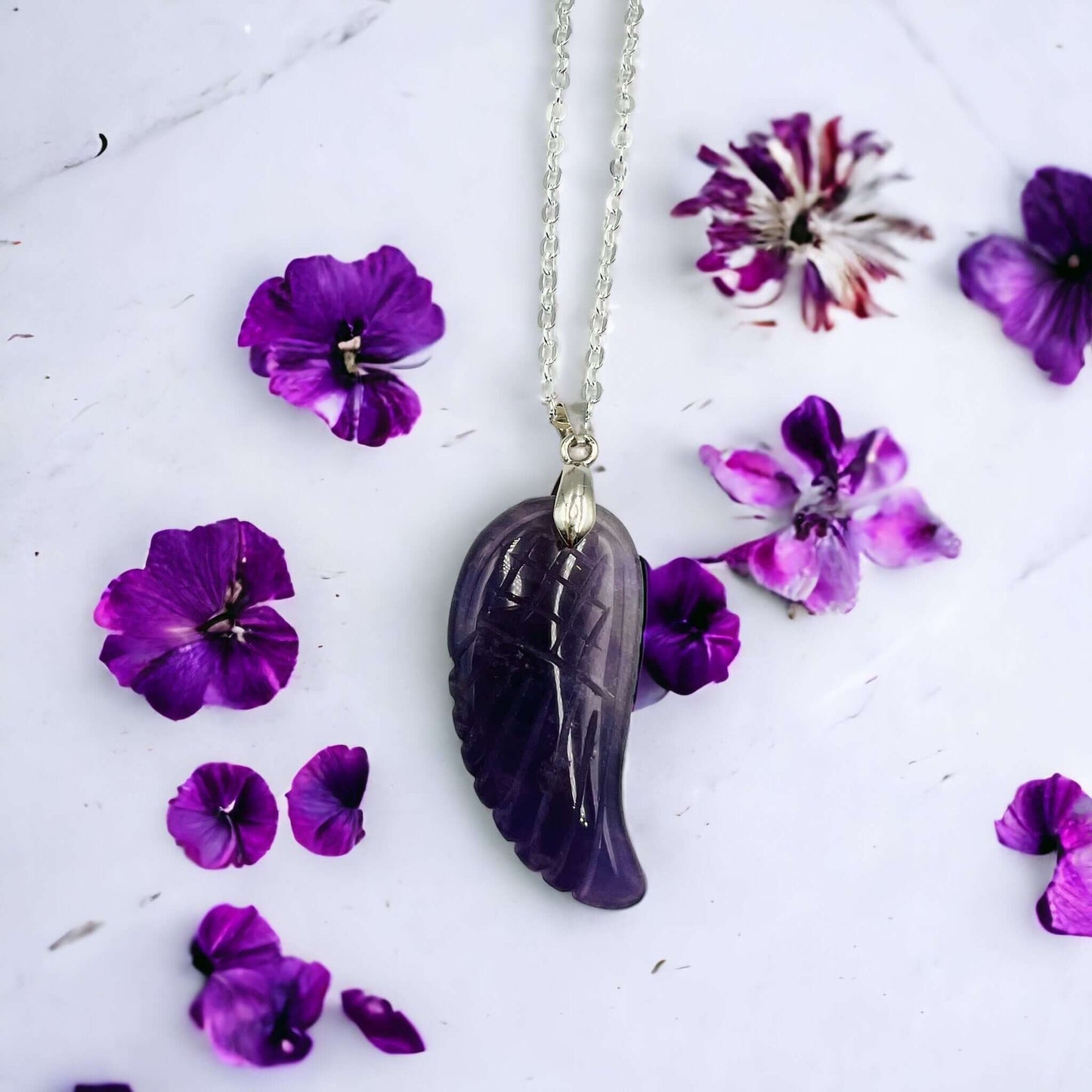 Carved amethyst Angel wing pendant on chain. 