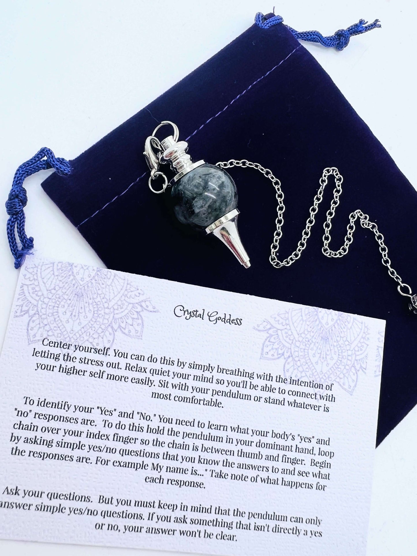 Crystal Ball Pendulum on pouch with information card on white background