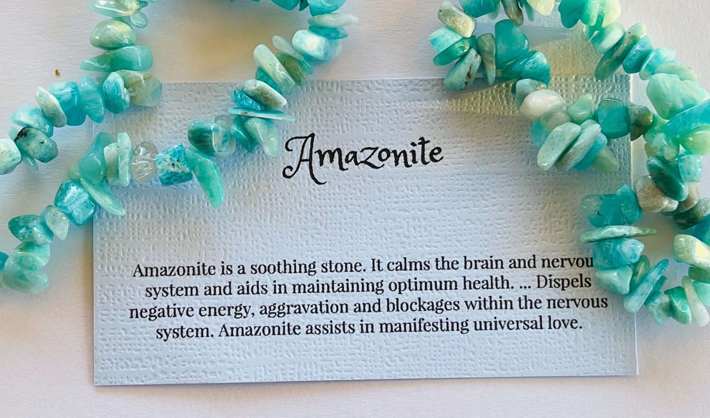 Amazonite crystal chip bracelet with information card on white background