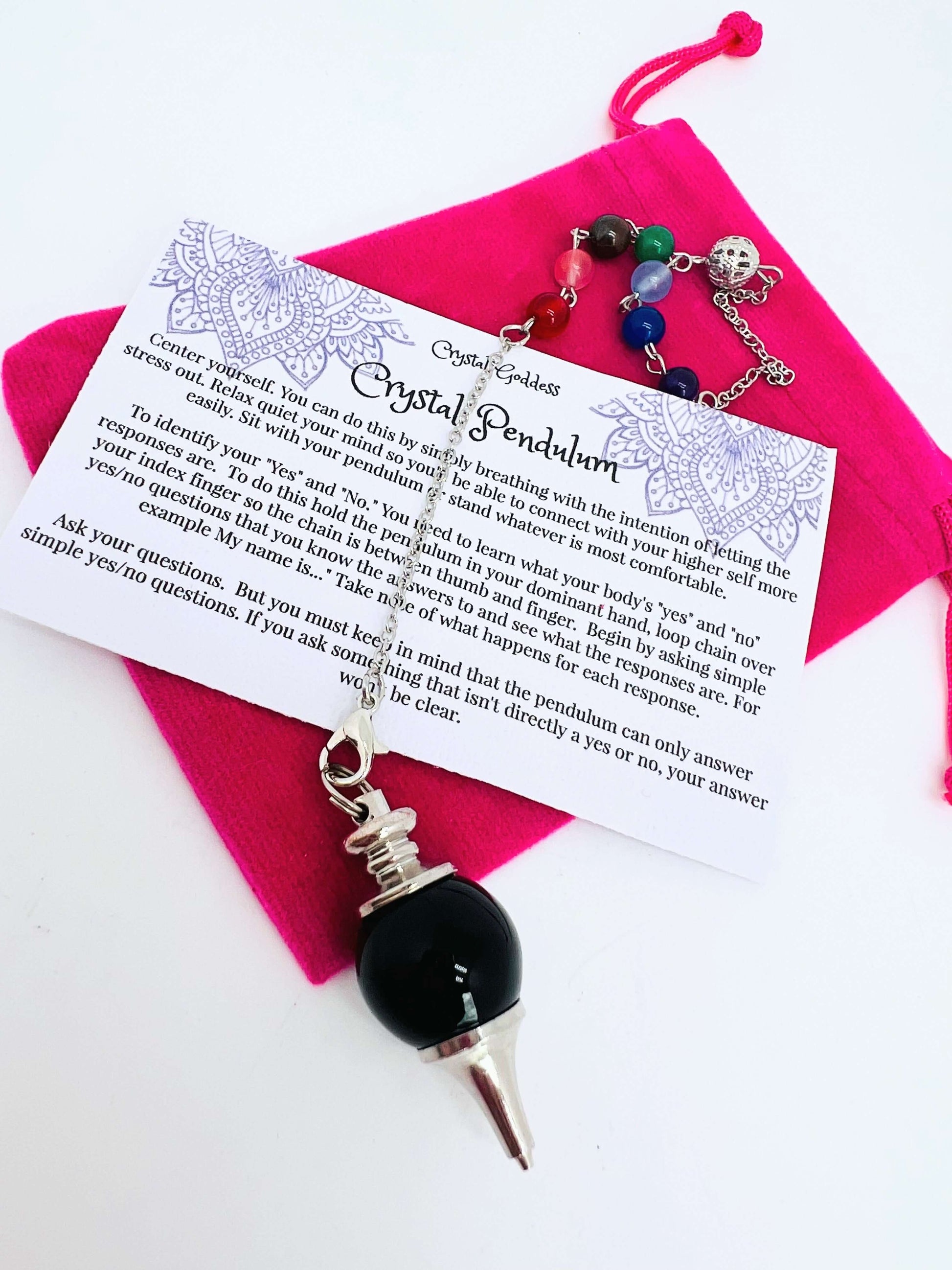 Crystal pendulum with pouch and instructions on white background