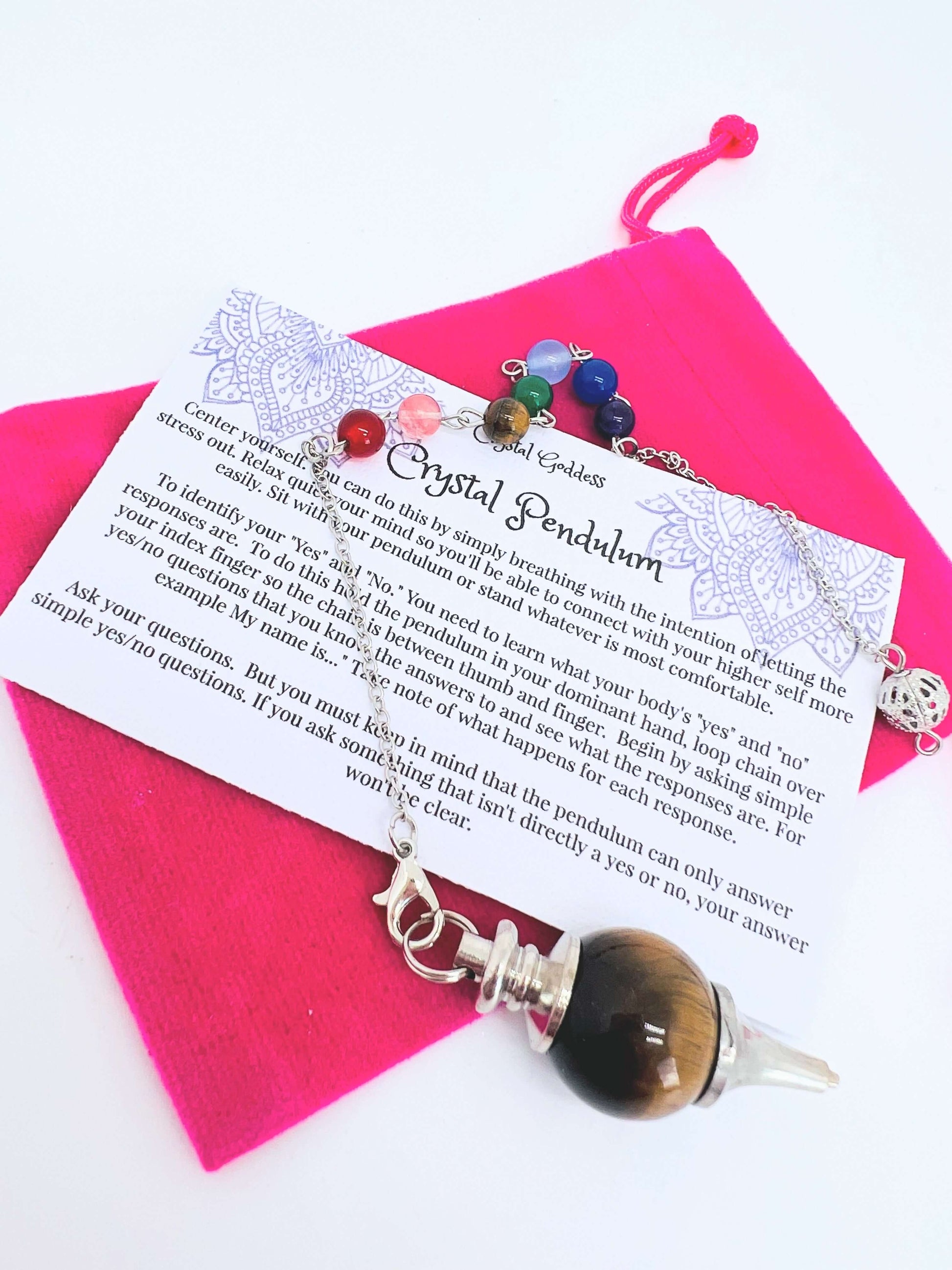 Crystal pendulum with pouch and instructions on white background