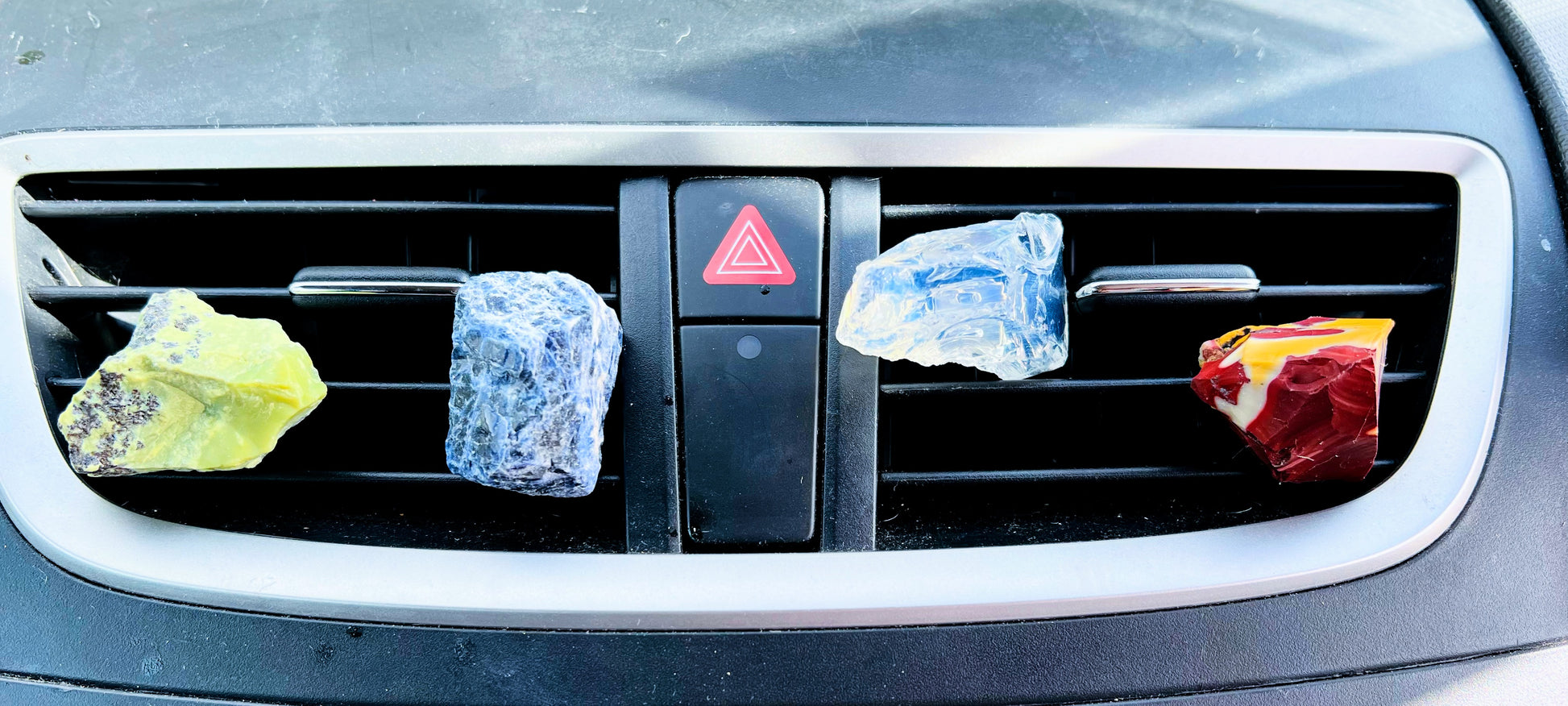 4 rough crystal car vent crystals shown on a car vent.