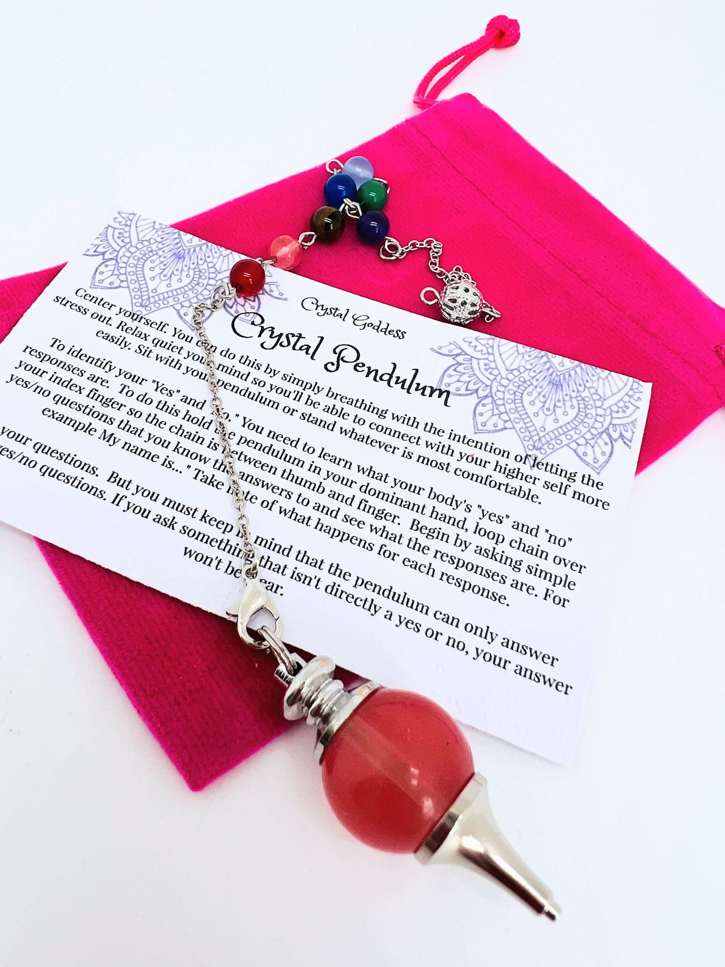 Crystal pendulum with pouch and instructions on white background