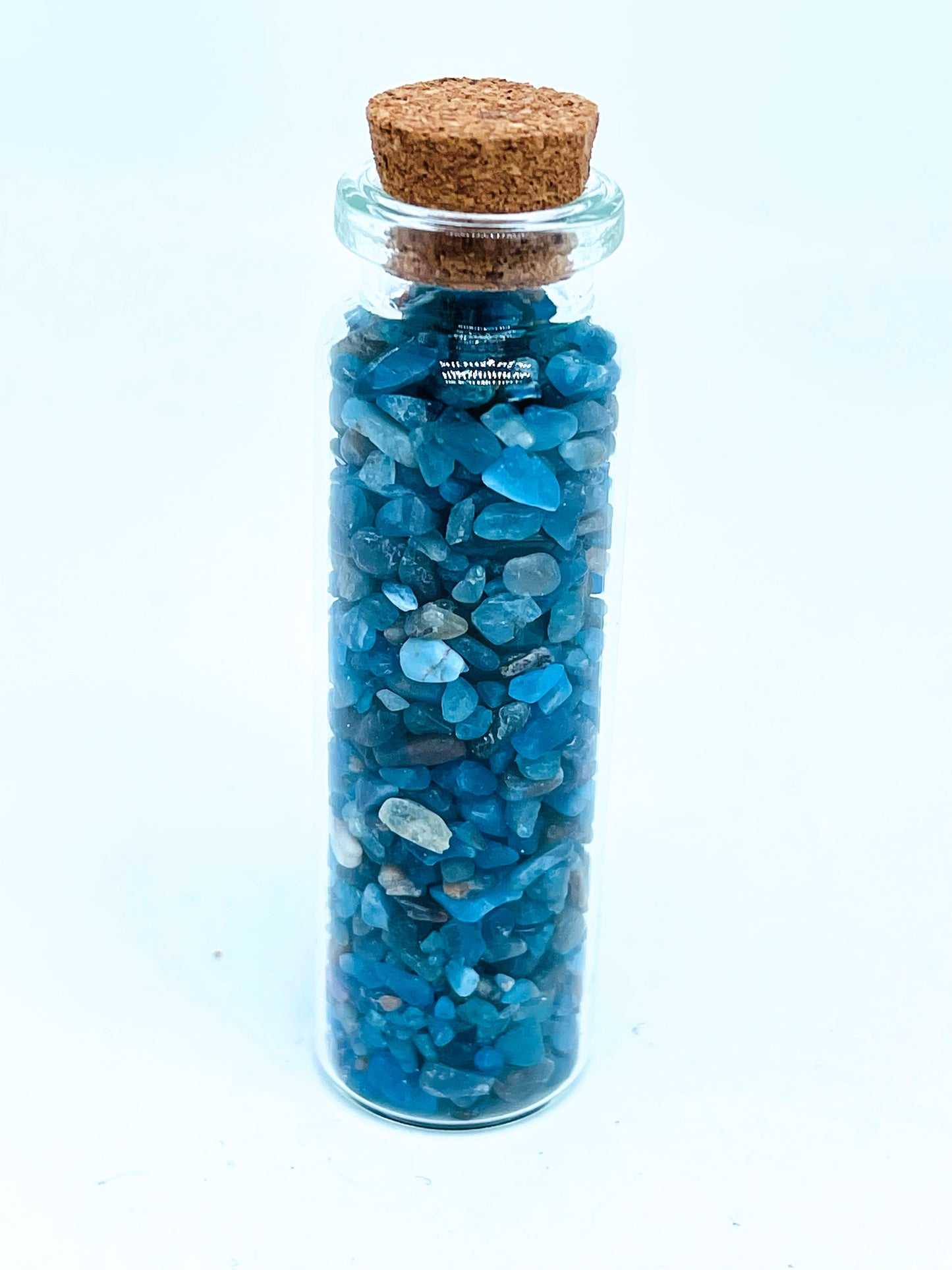 Apatite crystal chip bottle on white background