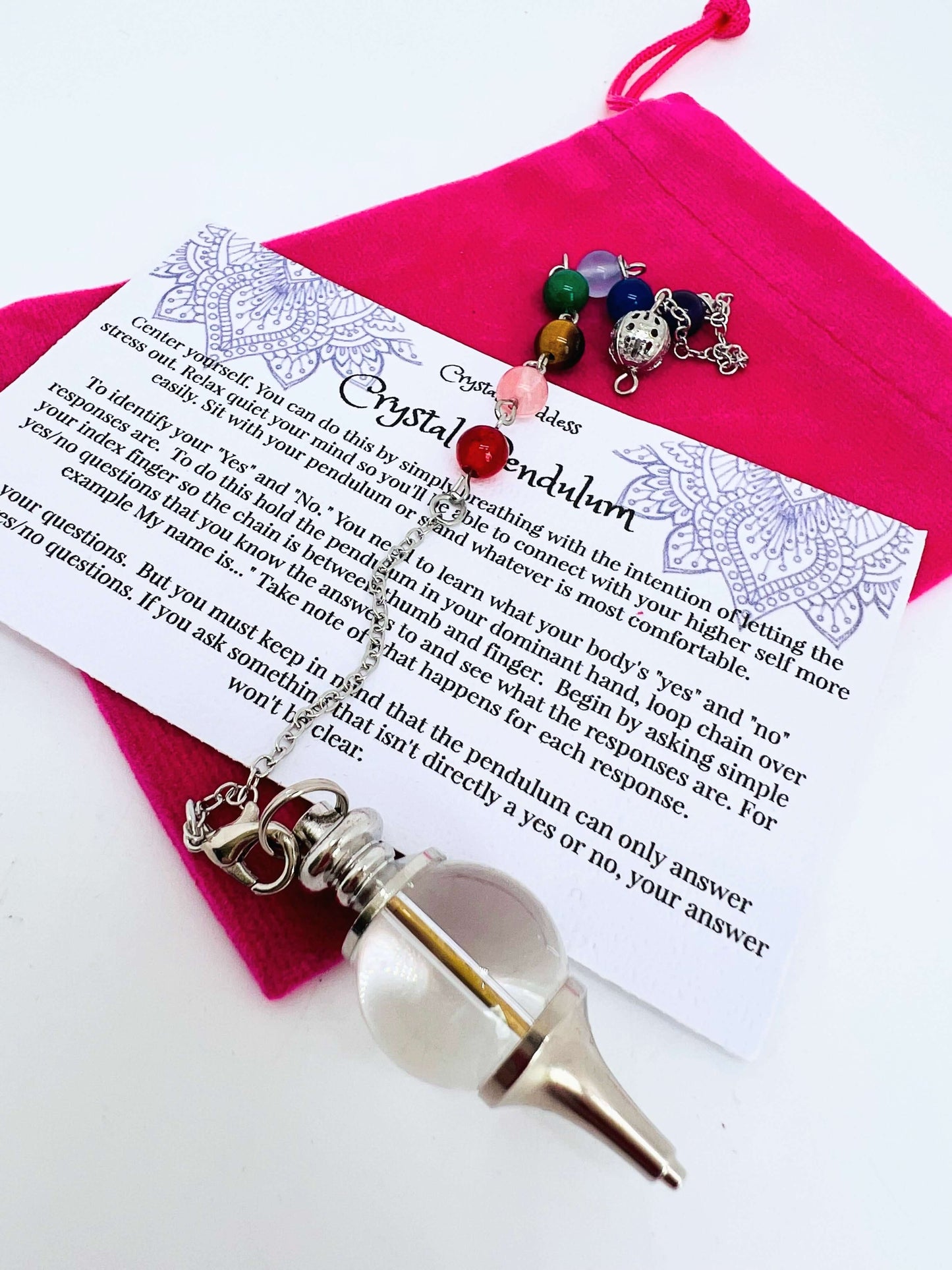 Crystal pendulum with pouch and instructions on white background