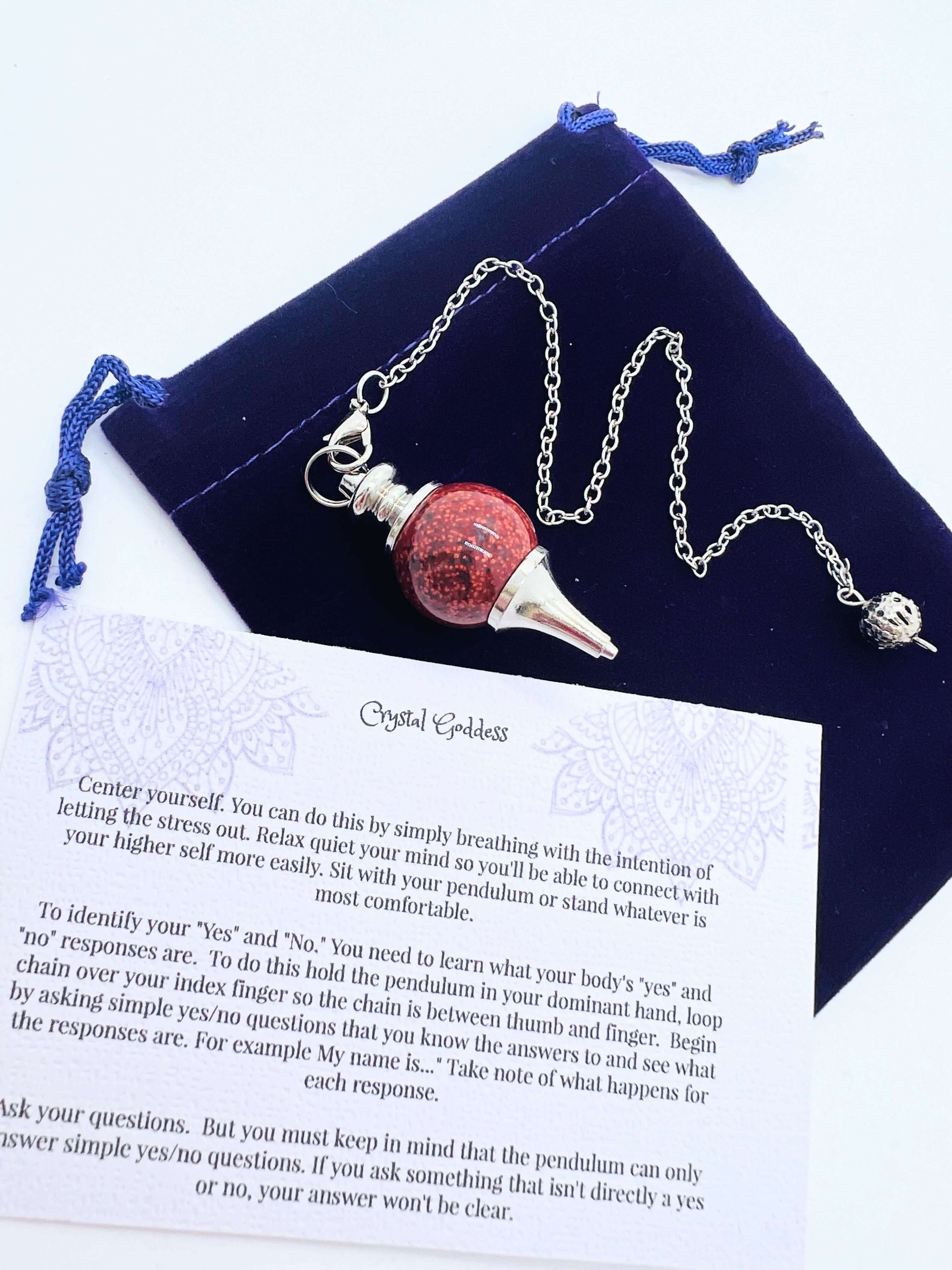 Crystal Ball Pendulum on pouch with information card on white background