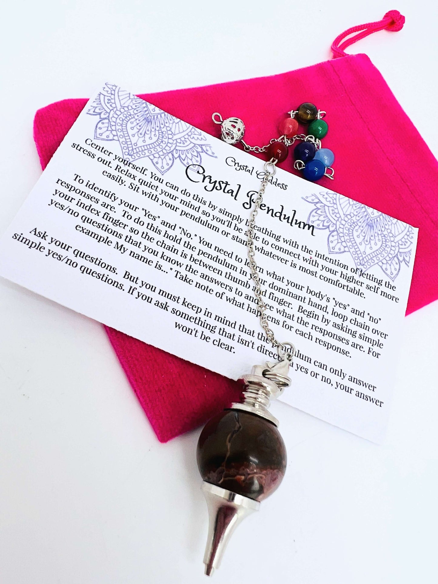 Crystal pendulum with pouch and instructions on white background