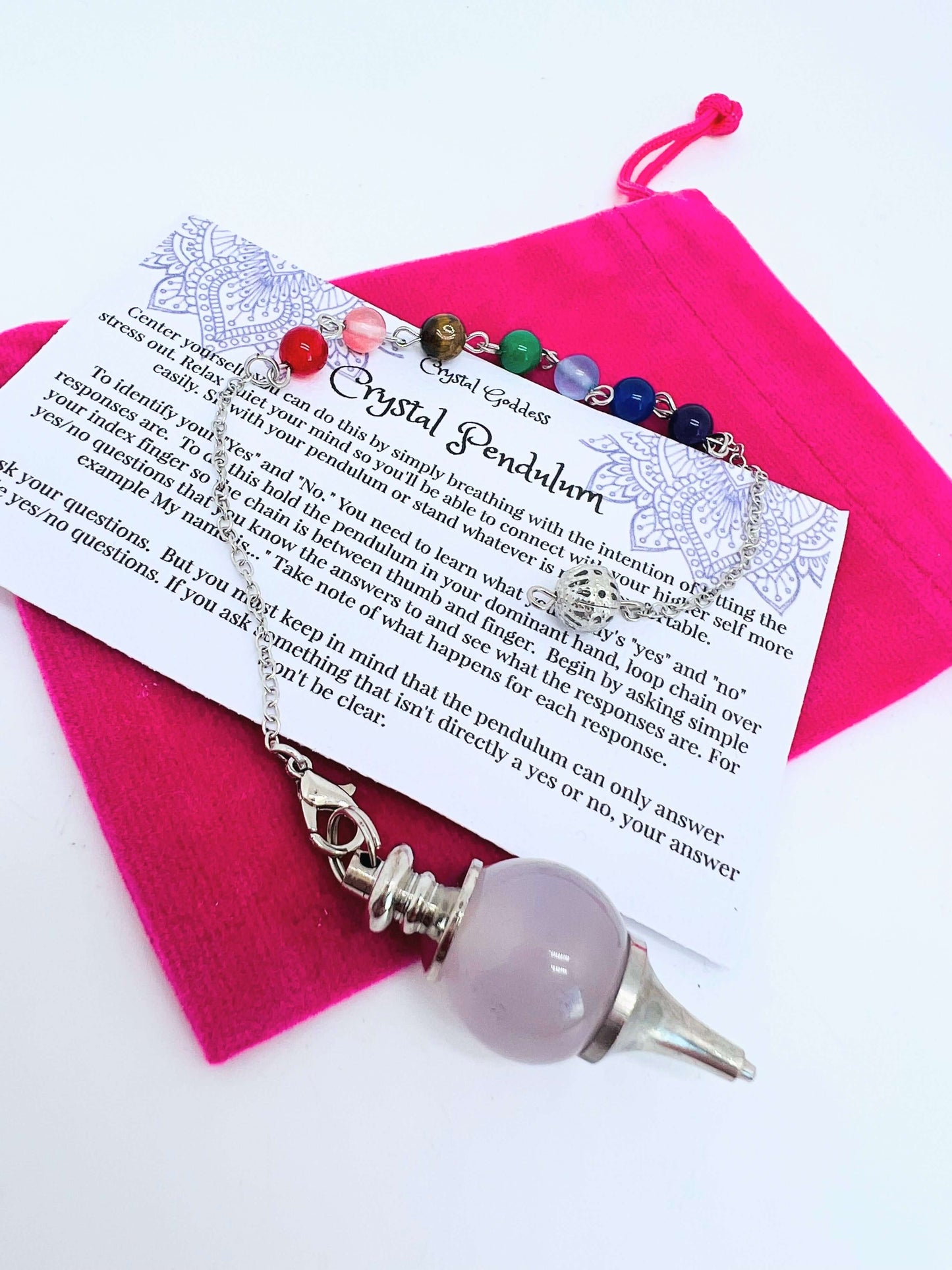 Crystal pendulum with pouch and instructions on white background