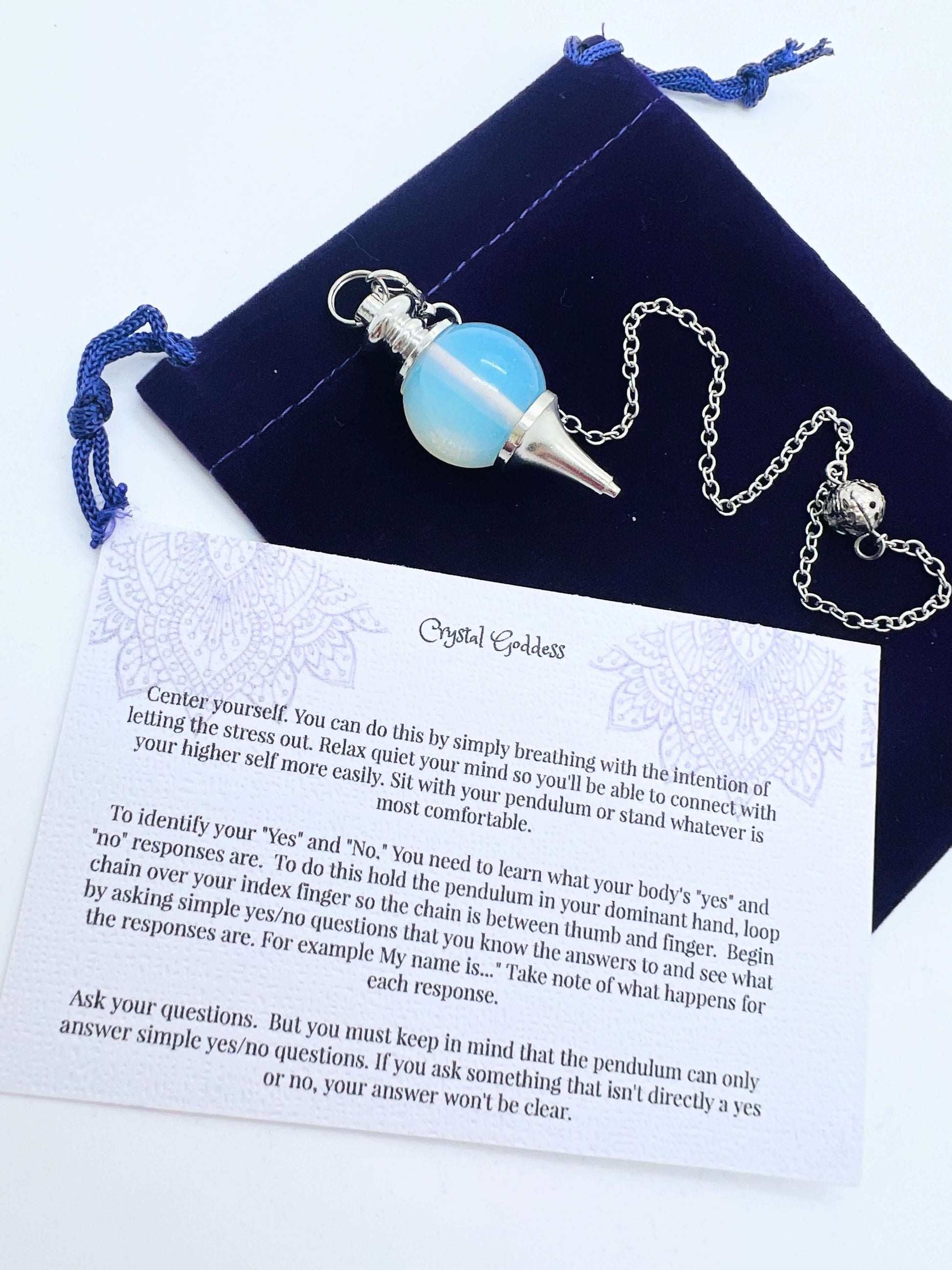 Crystal Ball Pendulum on pouch with information card on white background