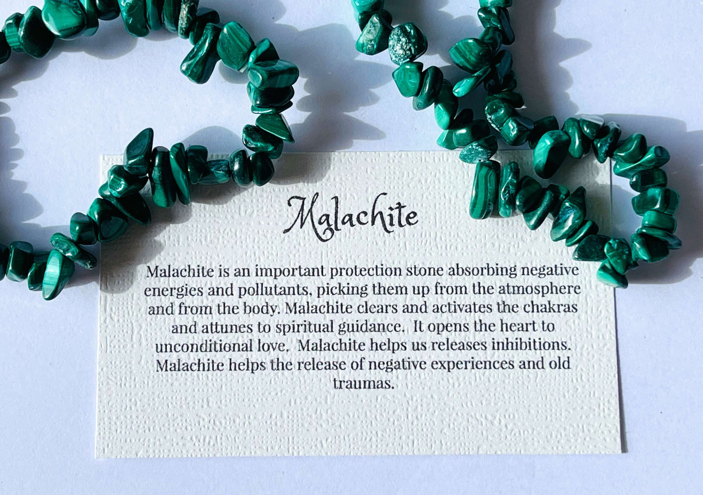 Malachite crystal chip bracelet with information card on white background