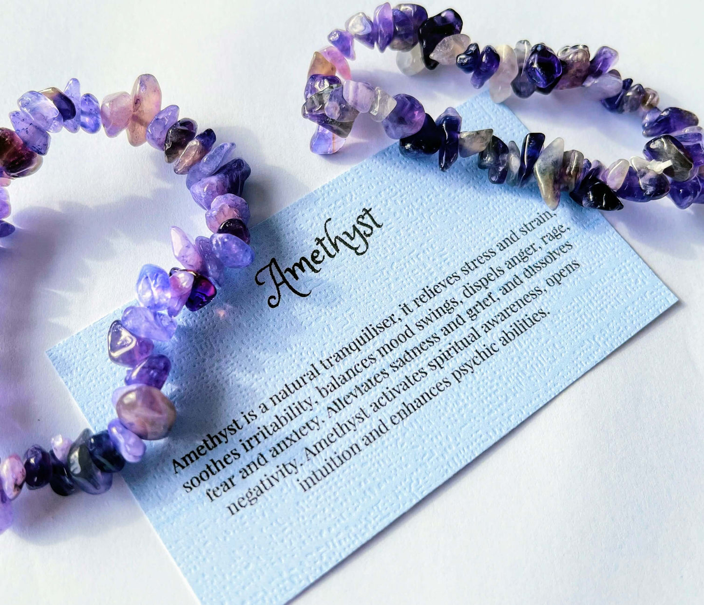 Amethyst crystal chip bracelet with information card on white background