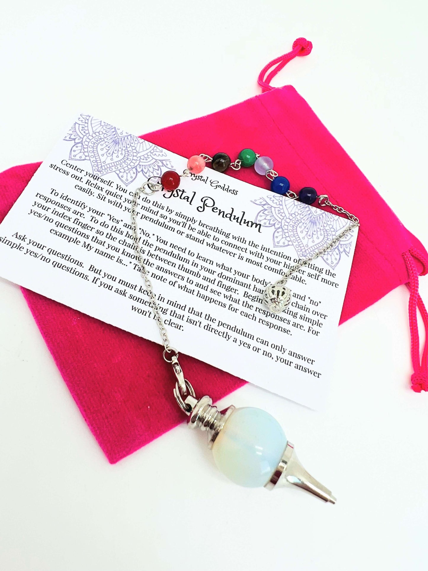 Crystal pendulum with pouch and instructions on white background