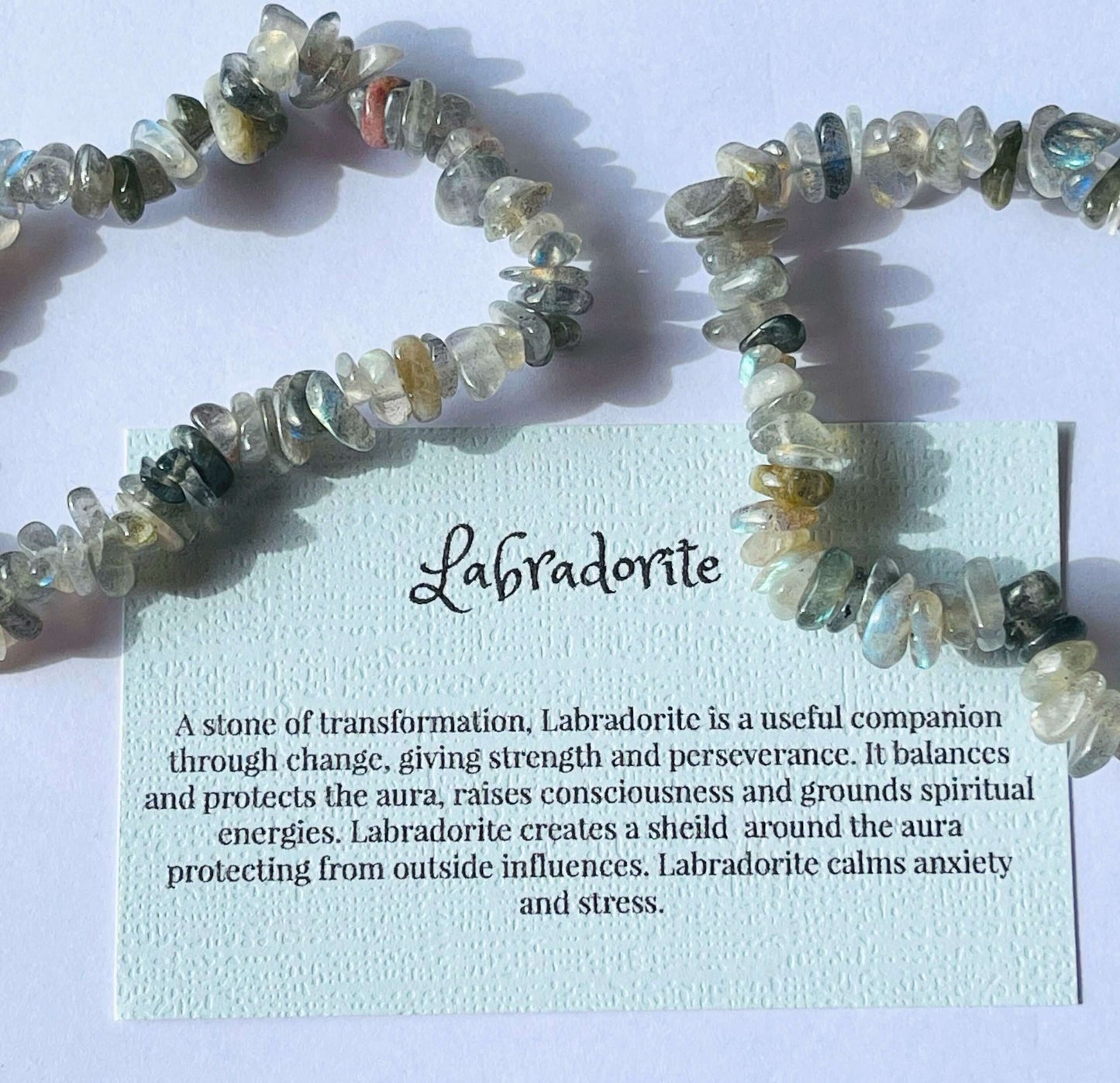 Labradorite crystal chip bracelet with information card on white background