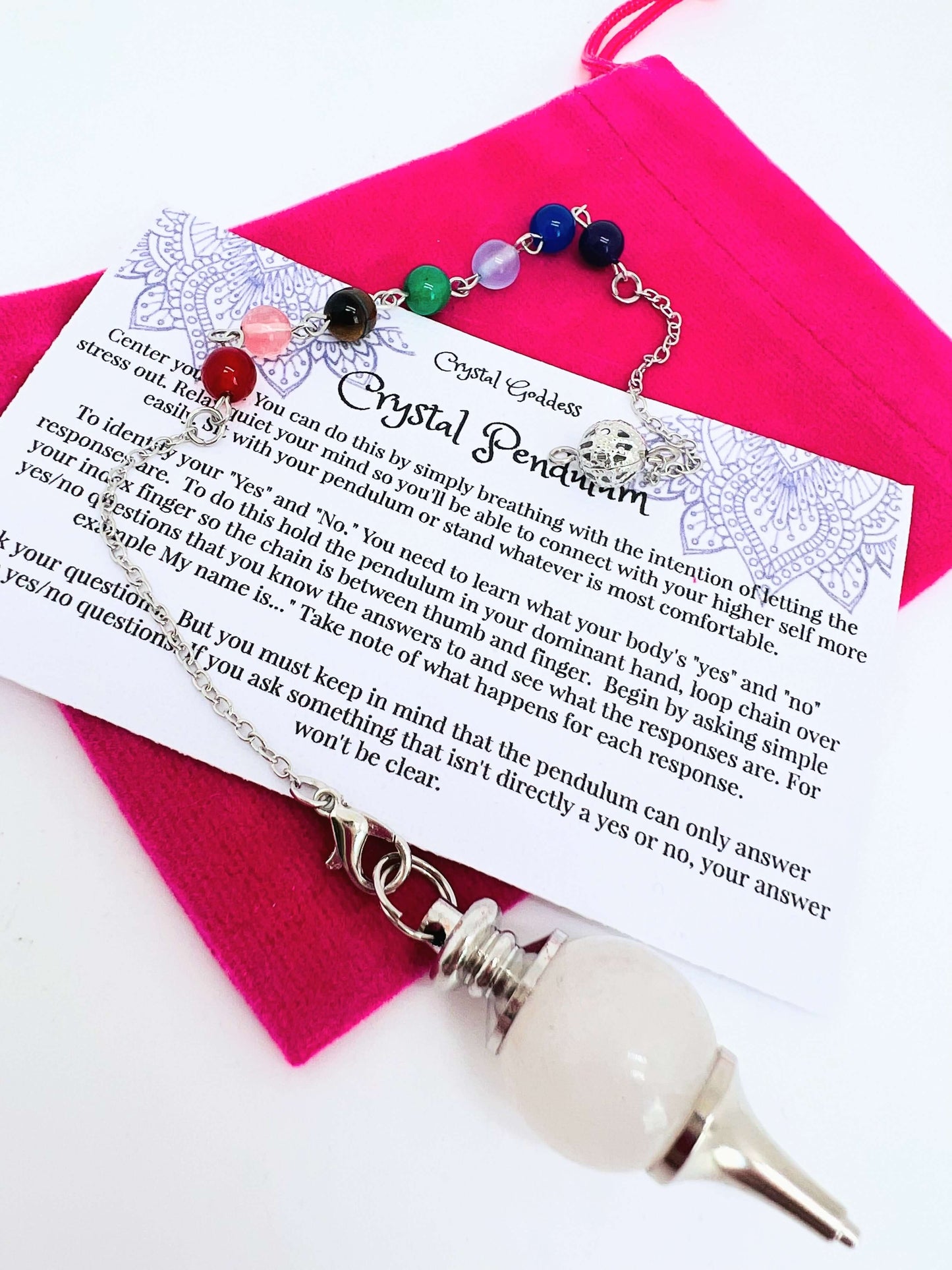 Crystal pendulum with pouch and instructions on white background