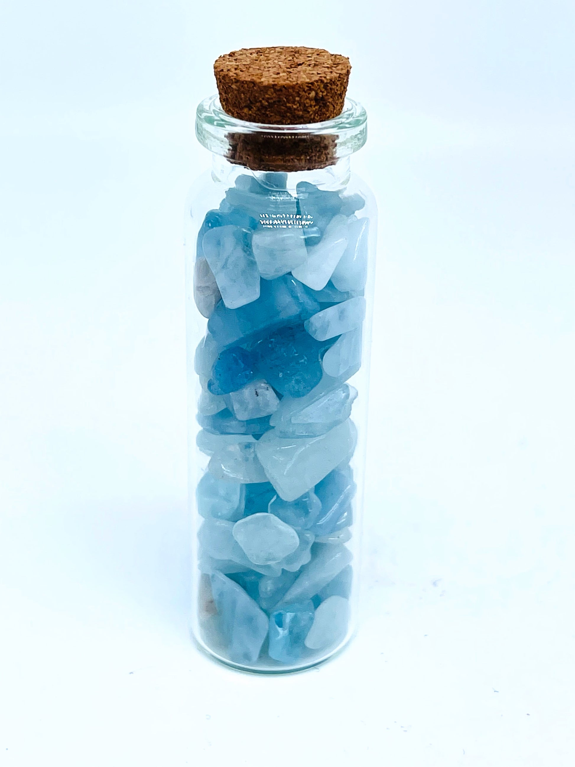 Aquamarine crystal chip bottle on white background