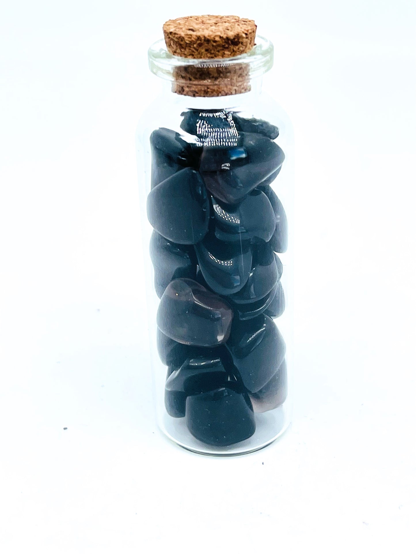 Obsidian crystal chip bottle on white background