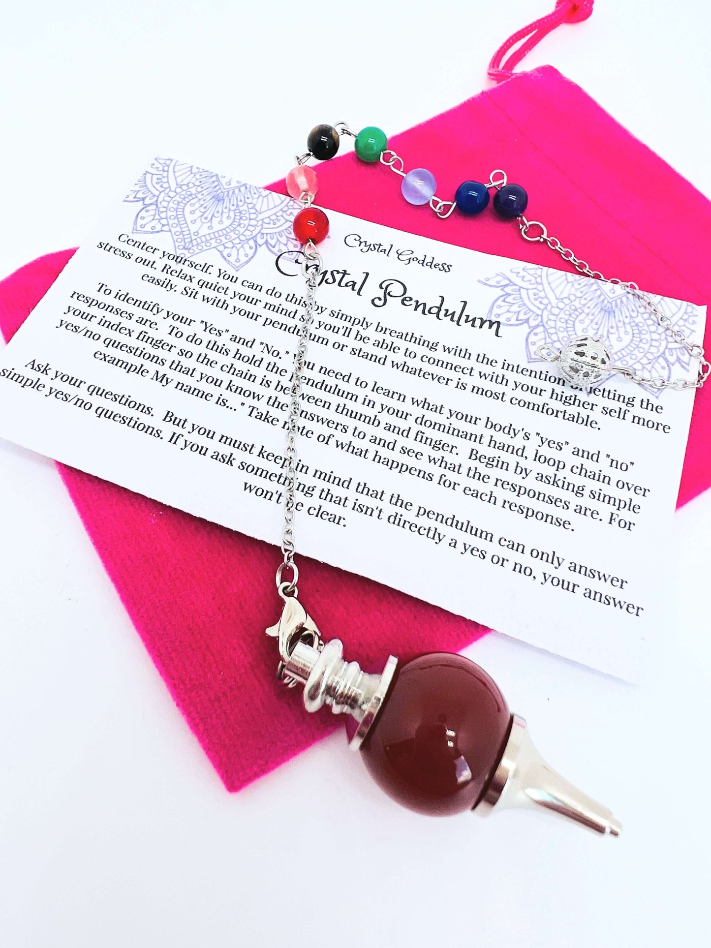 Crystal pendulum with pouch and instructions on white background