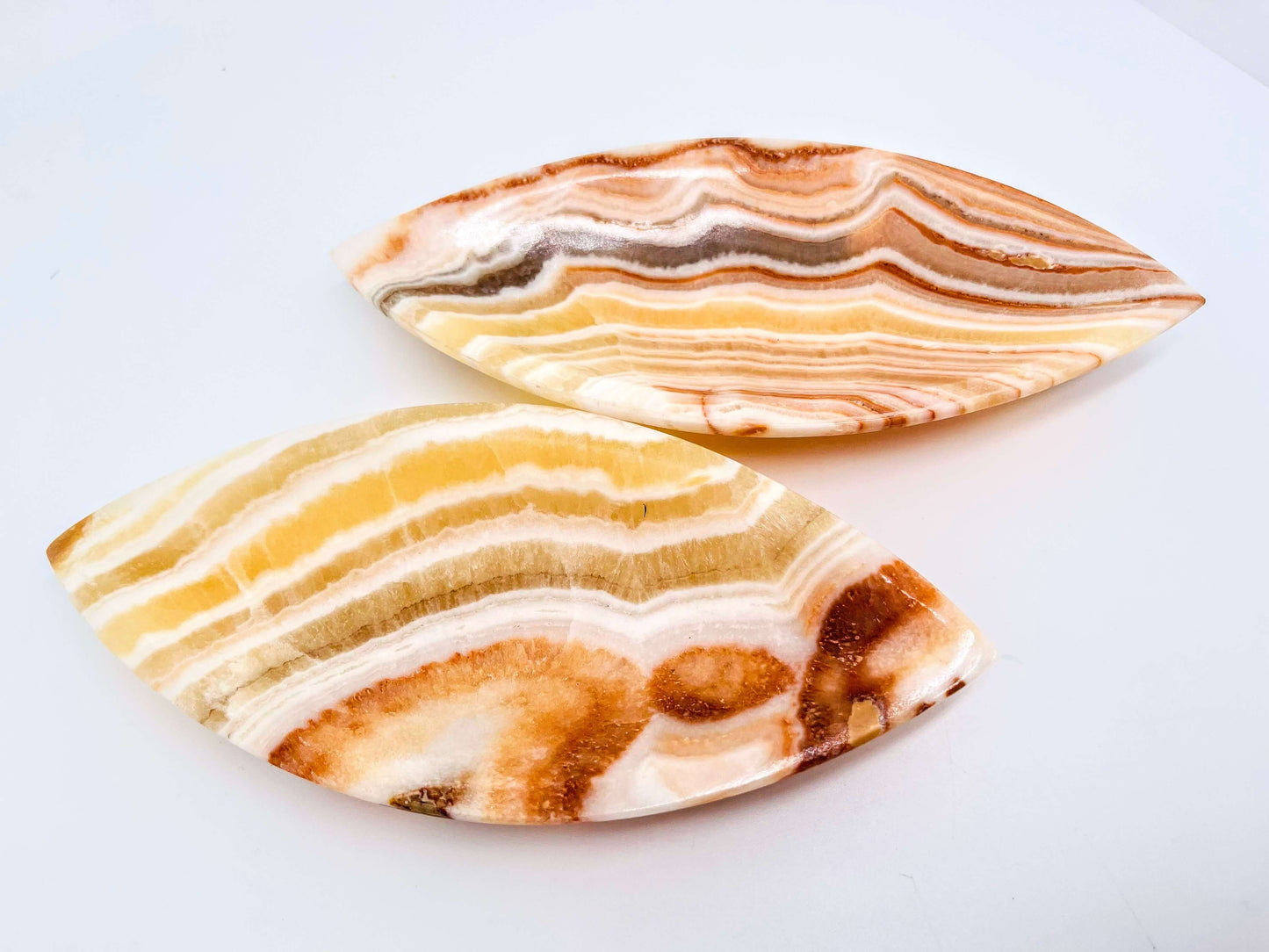 Orange calcite crystal bowls on white background 