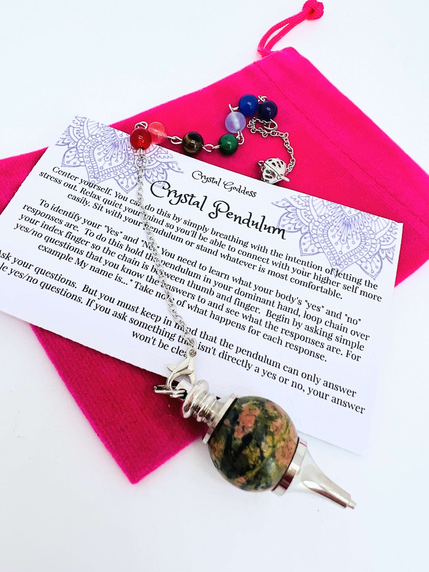 Crystal pendulum with pouch and instructions on white background