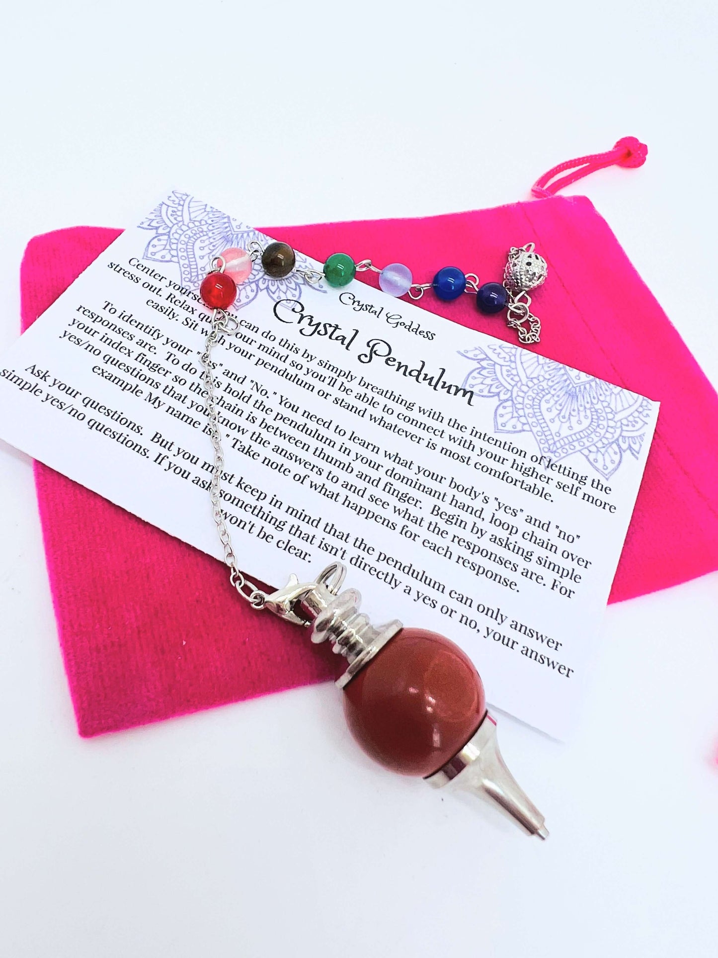 Crystal pendulum with pouch and instructions on white background