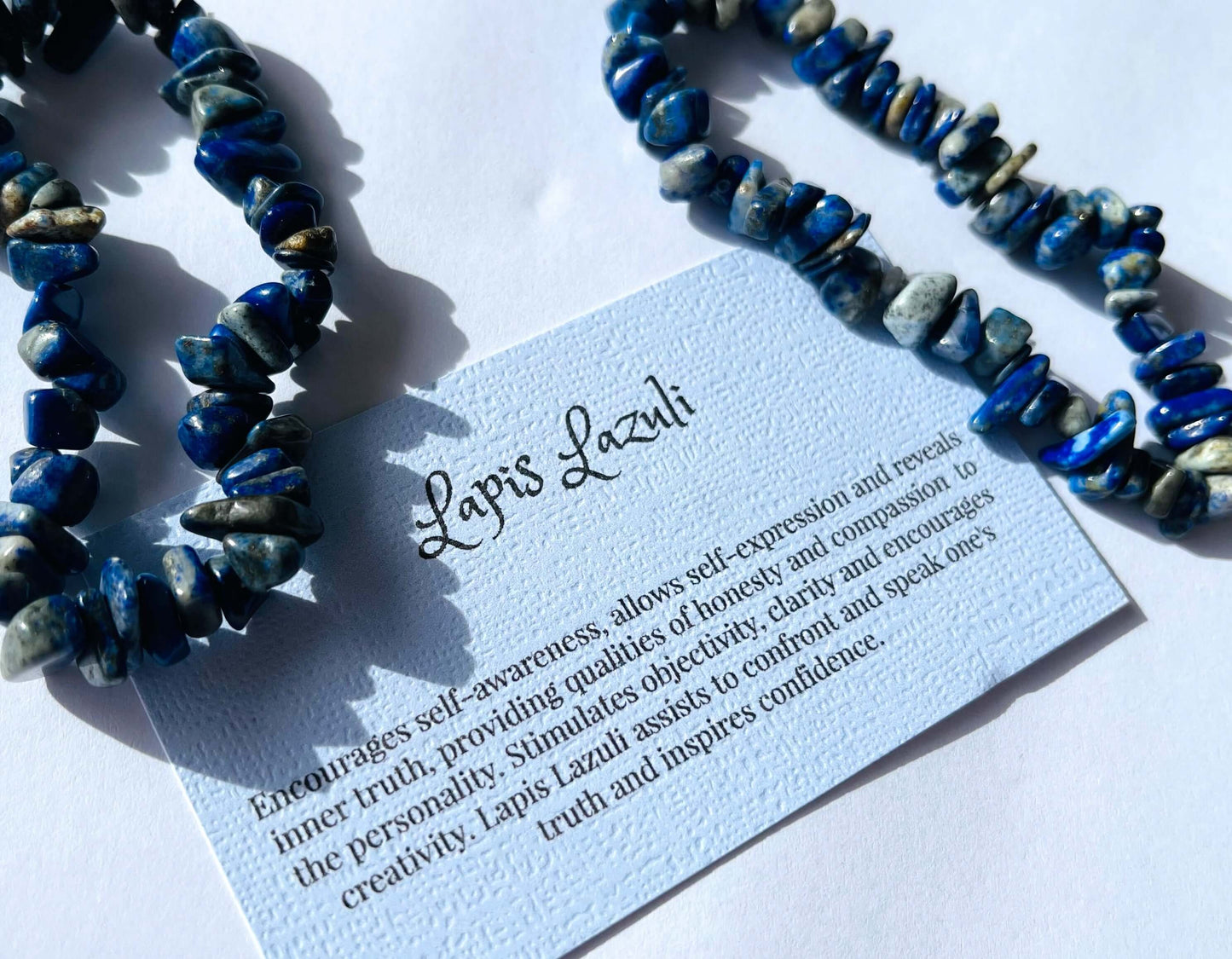 Lapis crystal chip bracelet with information card on white background