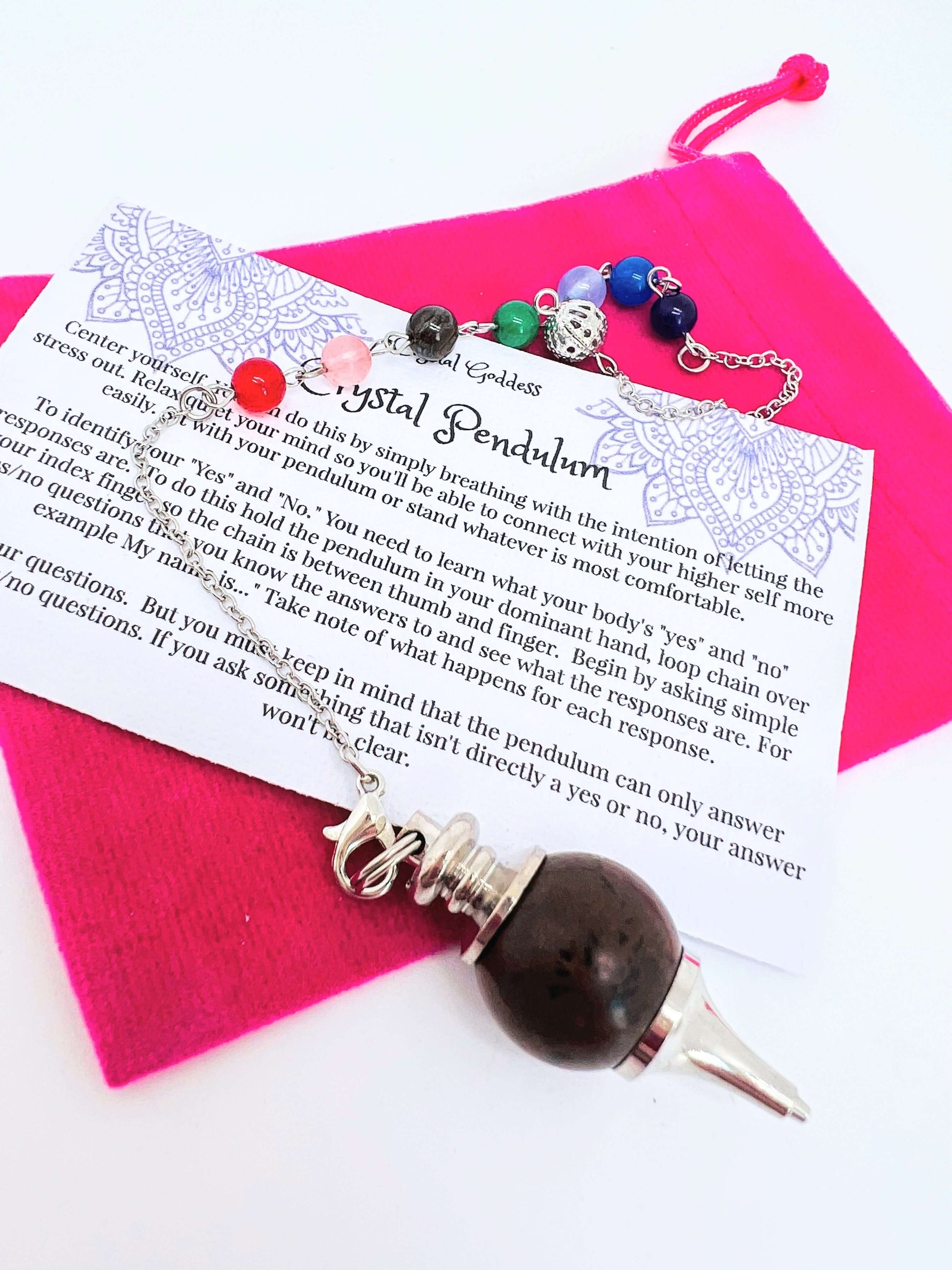 Crystal pendulum with pouch and instructions on white background