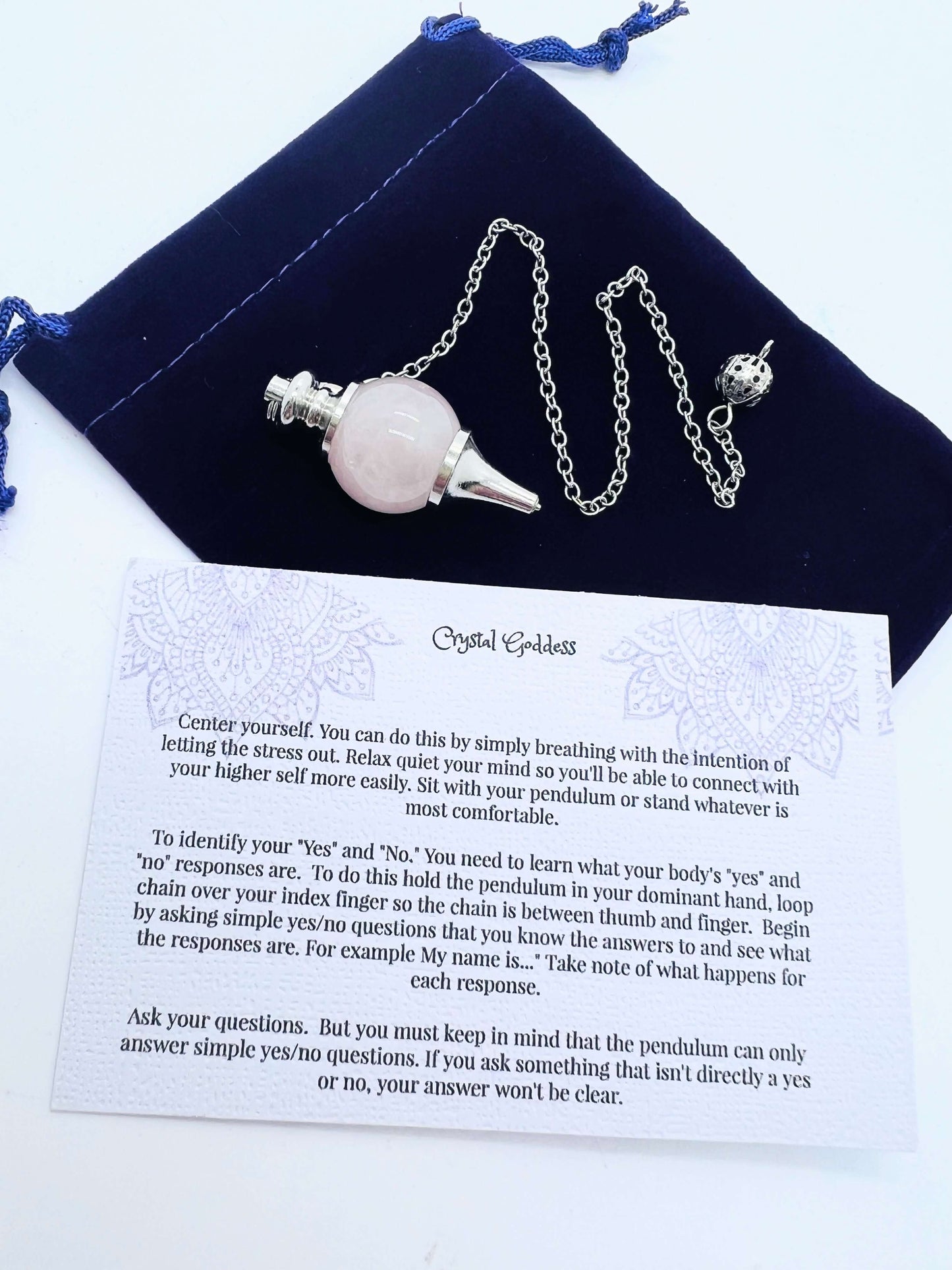 Crystal Ball Pendulum on pouch with information card on white background