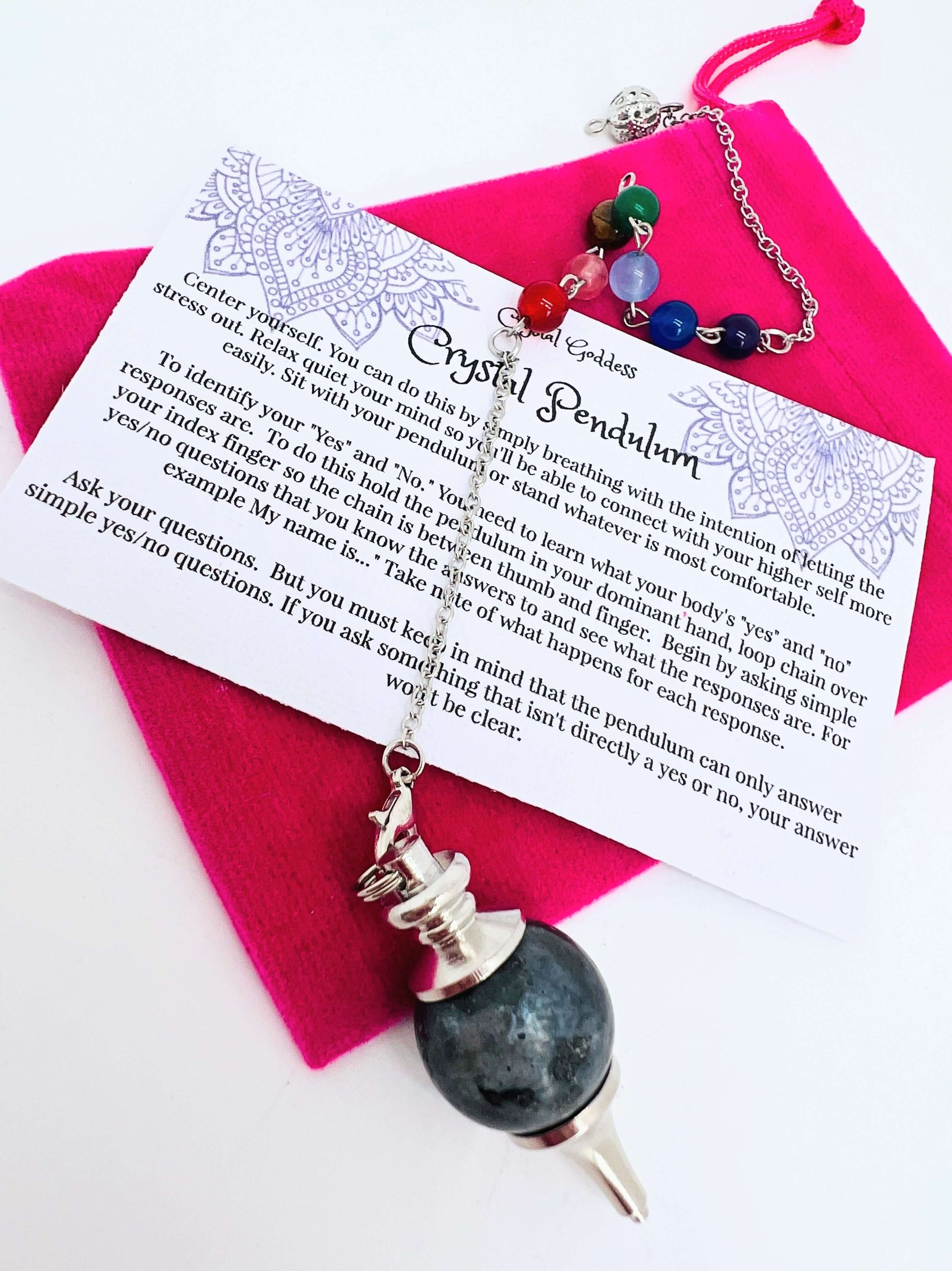 Crystal pendulum with pouch and instructions on white background