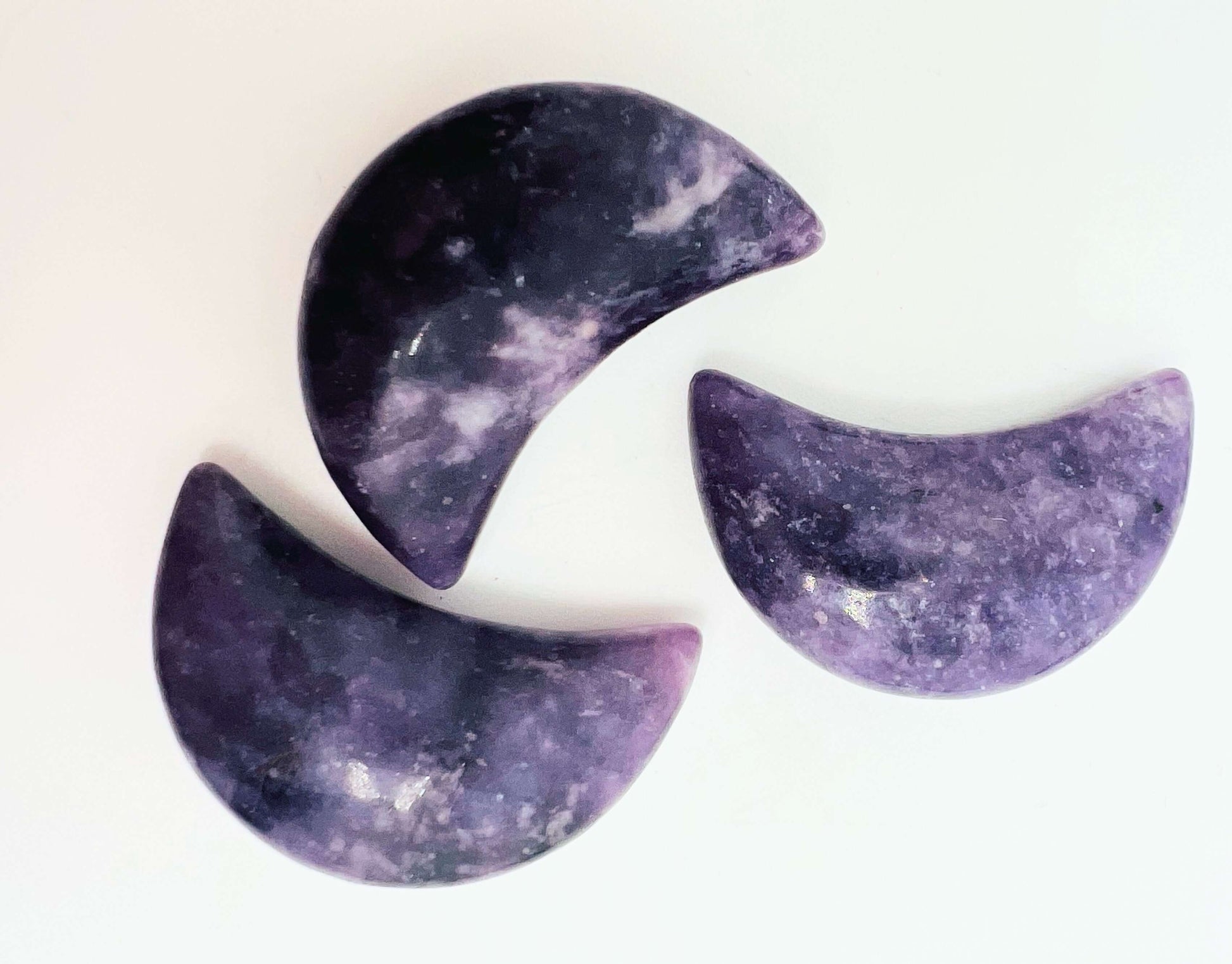  Three Crystal lepidolite moons on white background 