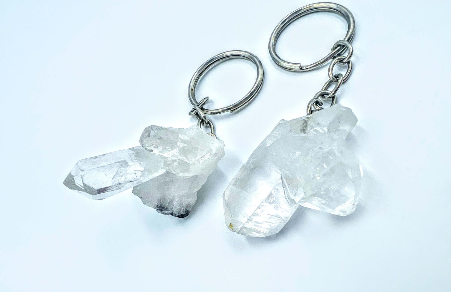 Crystal key rings on white surface with petals